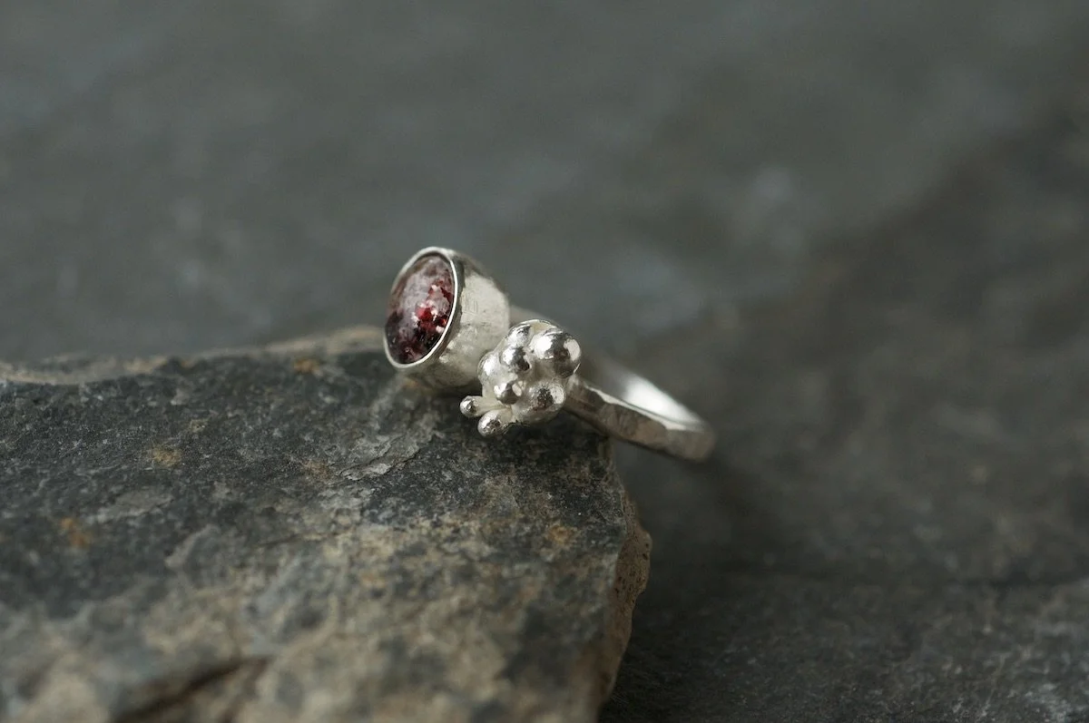 Fire quartz cabochon lichen cluster ring showing red colour.jpeg