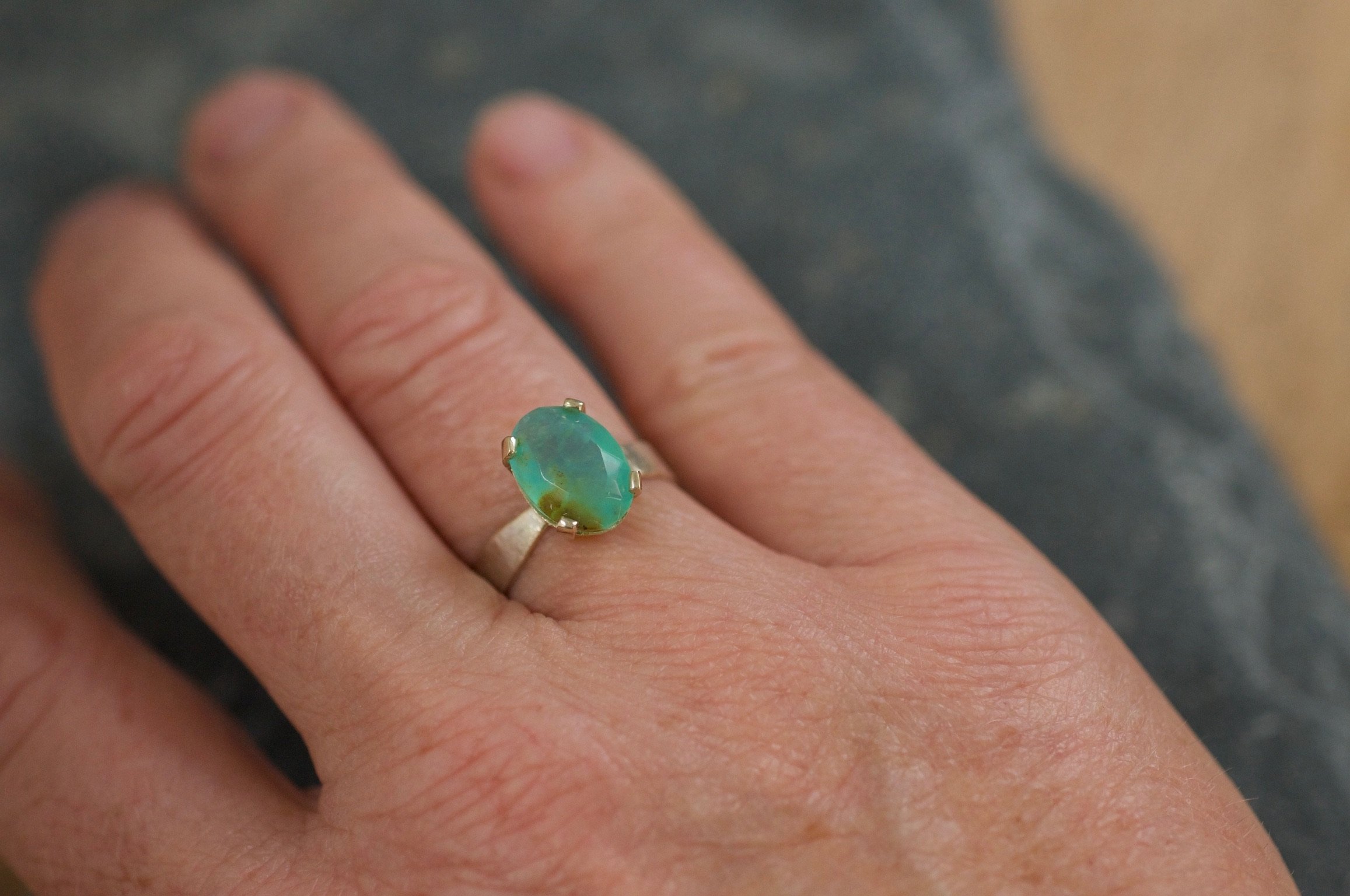 Elegant blue opal ring set in gold on a hand.jpeg