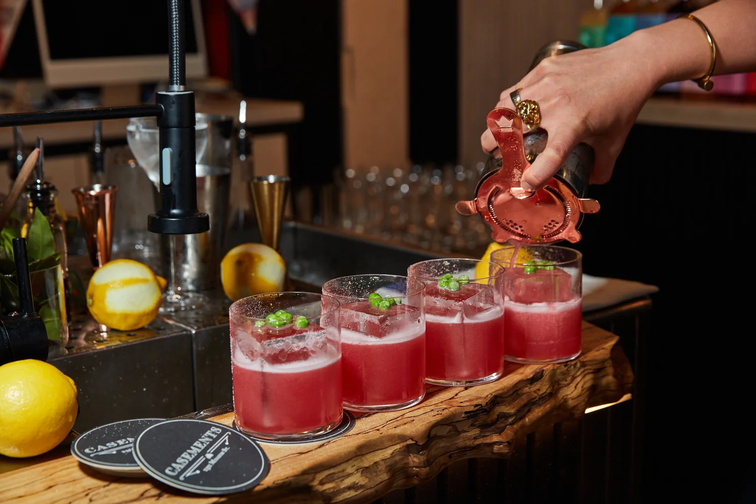 Casements in San Francisco, large clear ice cube in a red cocktail topped with green peas.