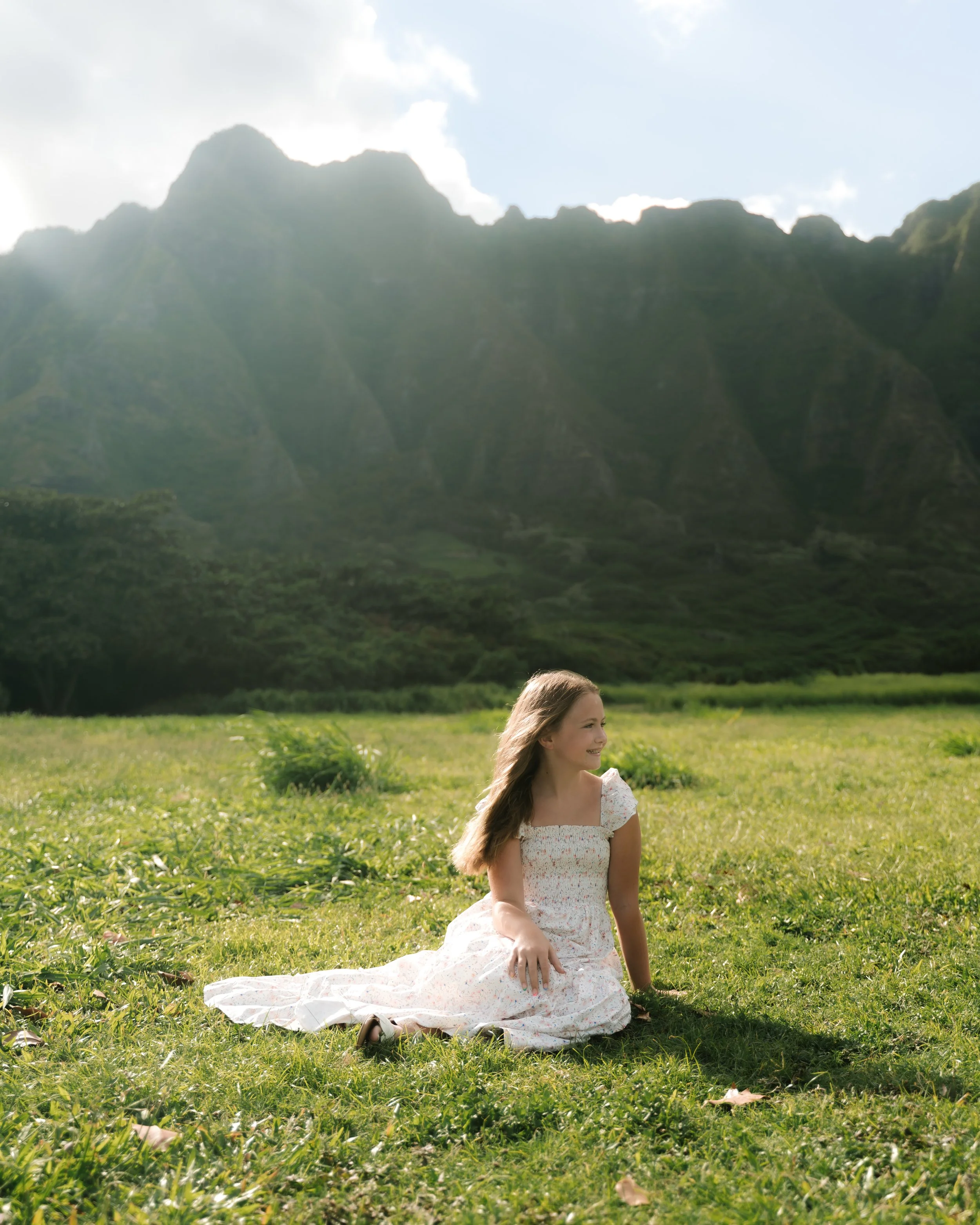 Family portrait with dramatic mountain views during an Oahu photography session at Kualoa Regional Park