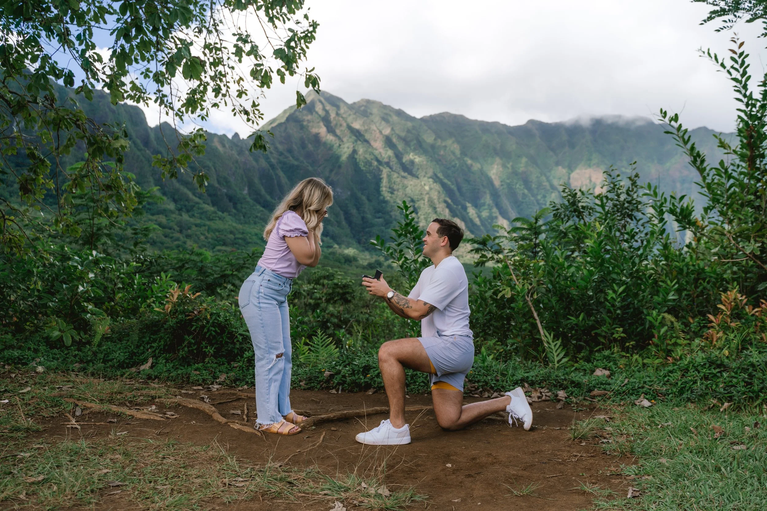 Surprise proposal surrounded by lush greenery during an Oahu proposal photography session at Ho‘omaluhia Botanical Garden.