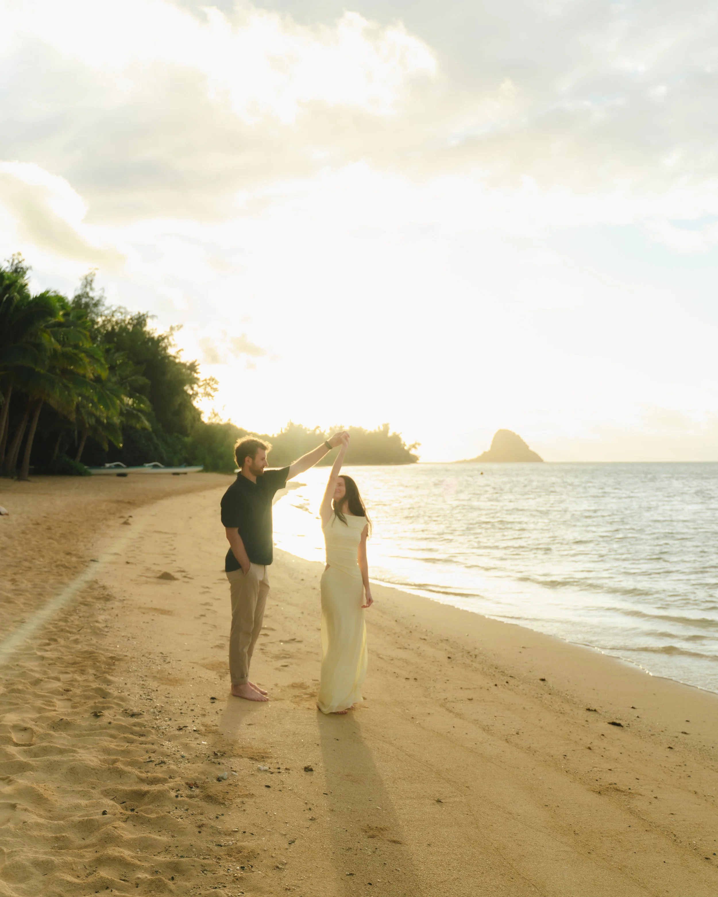 Newly engaged couple photographed at Kualoa Regional Park after a romantic Oahu sunrise proposal