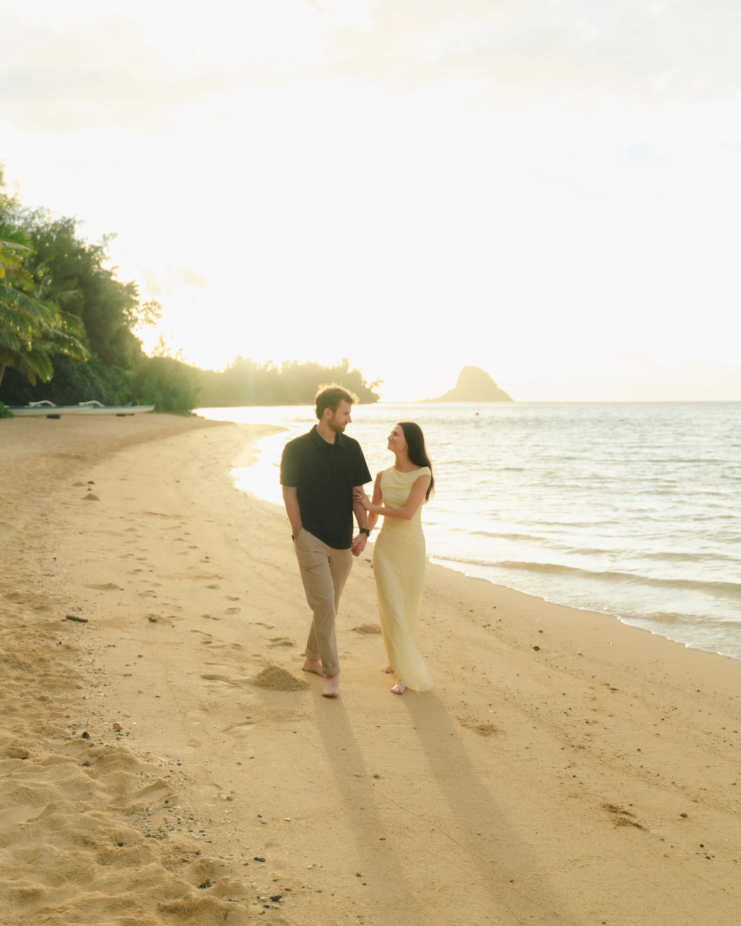 Newly engaged couple photographed at Kualoa Regional Park after a romantic Oahu sunrise proposal
