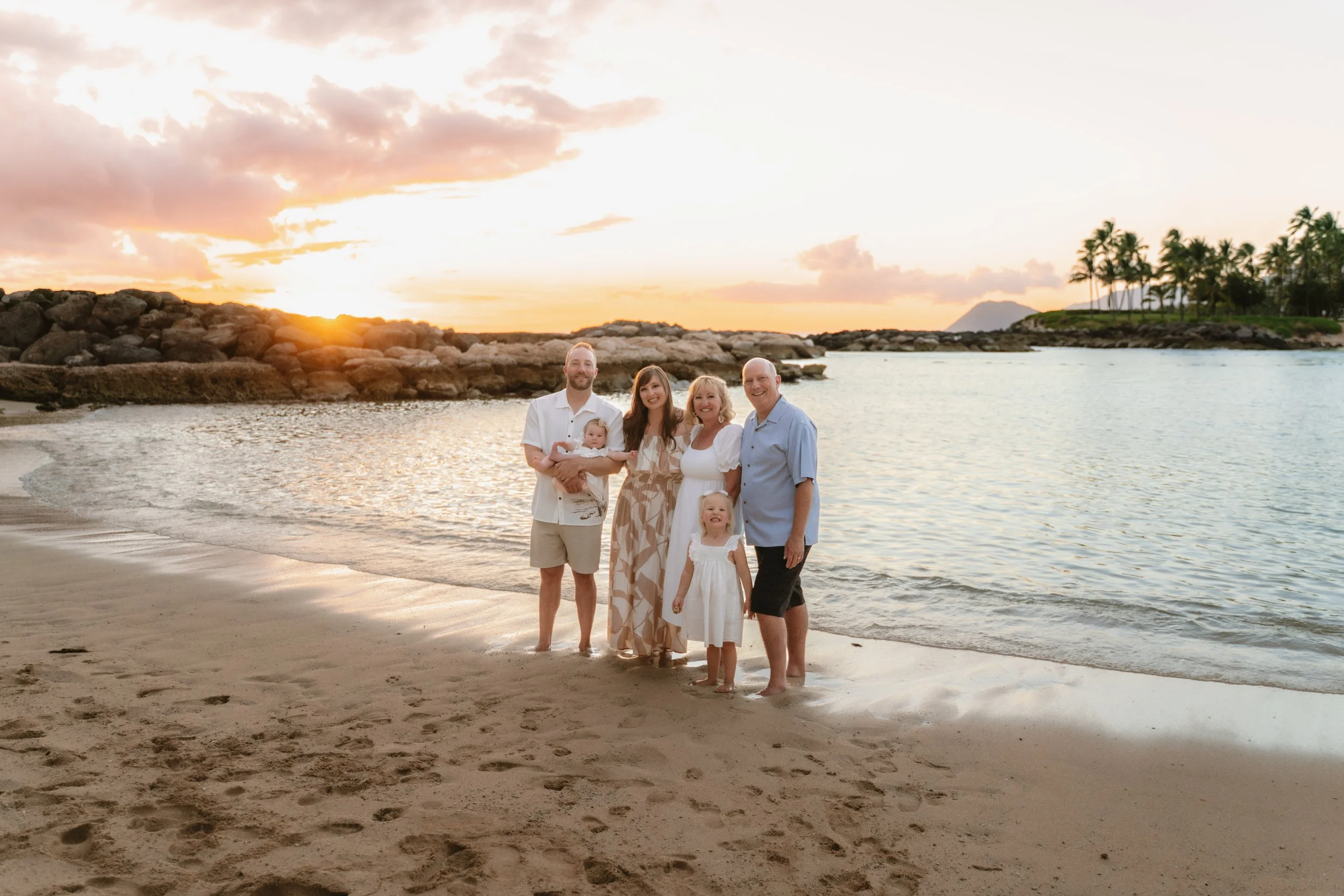 Multi-generational family portrait at Marriott Lagoon in Ko Olina during sunset with tropical Hawaii scenery and warm evening colors.