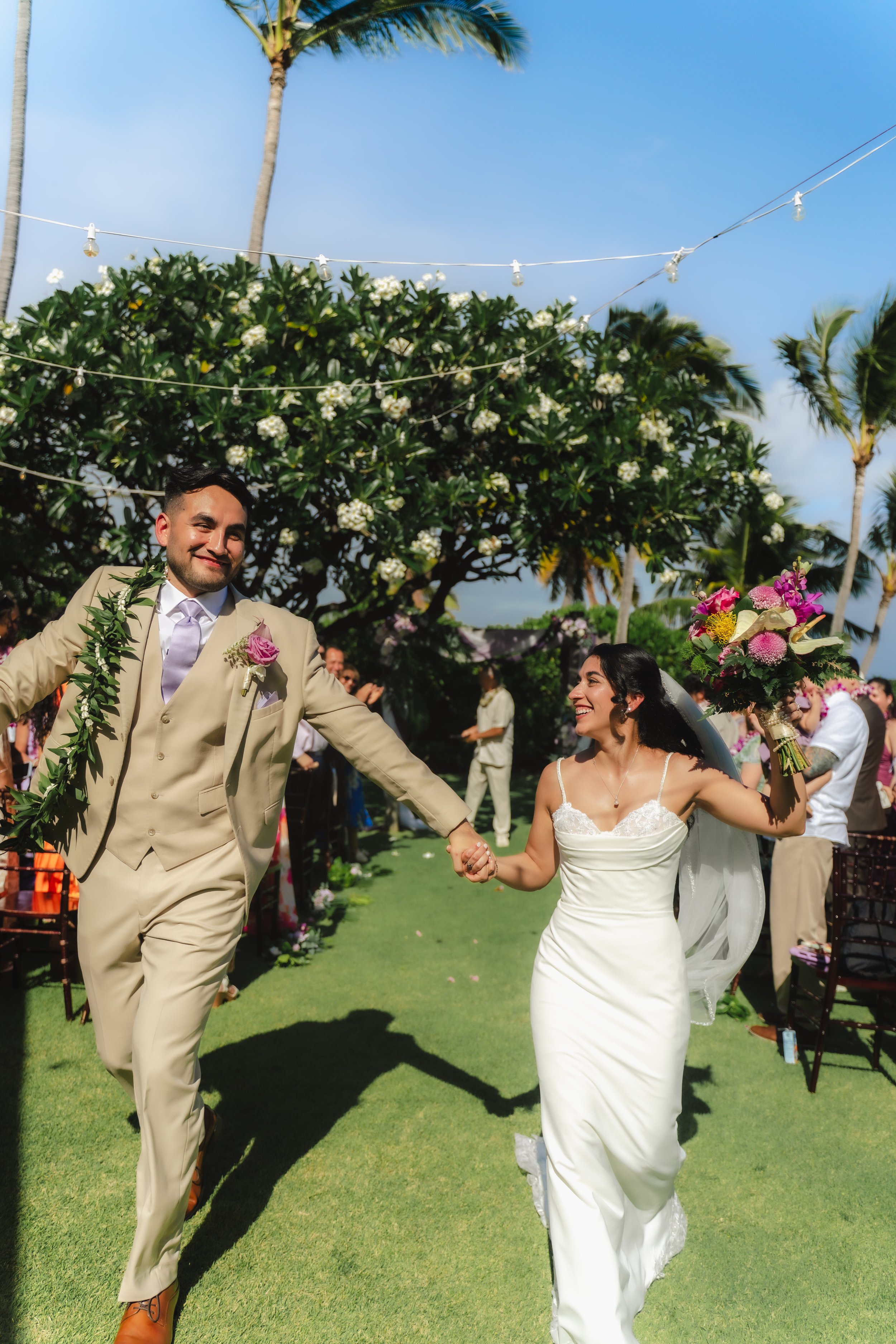 Newlyweds celebrating during their outdoor wedding ceremony at Kaimea Estates on Oahu
