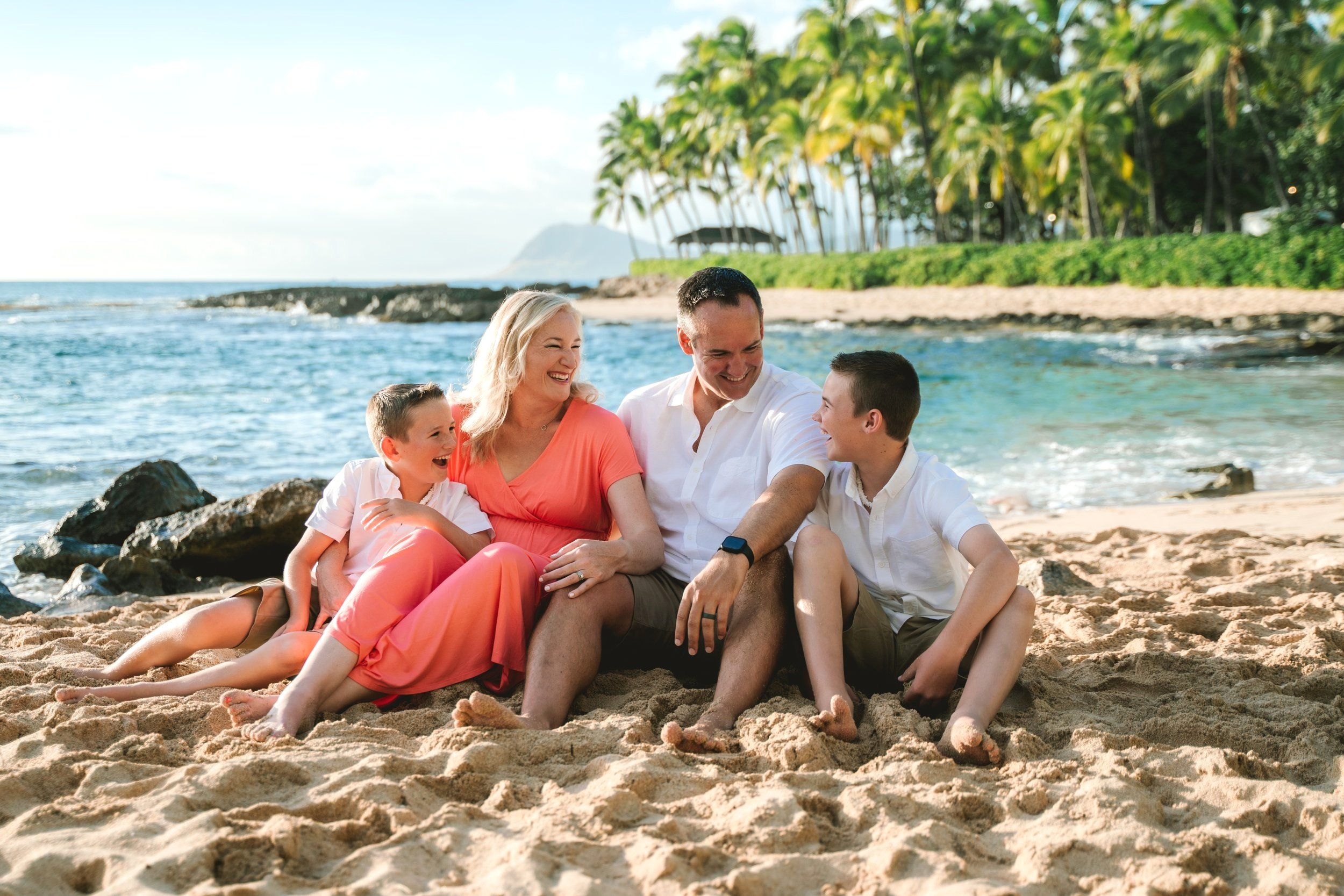 Family enjoying a beach session together during an Oahu family photography experience at Secret Beach in Ko Olina near Disney Aulani.