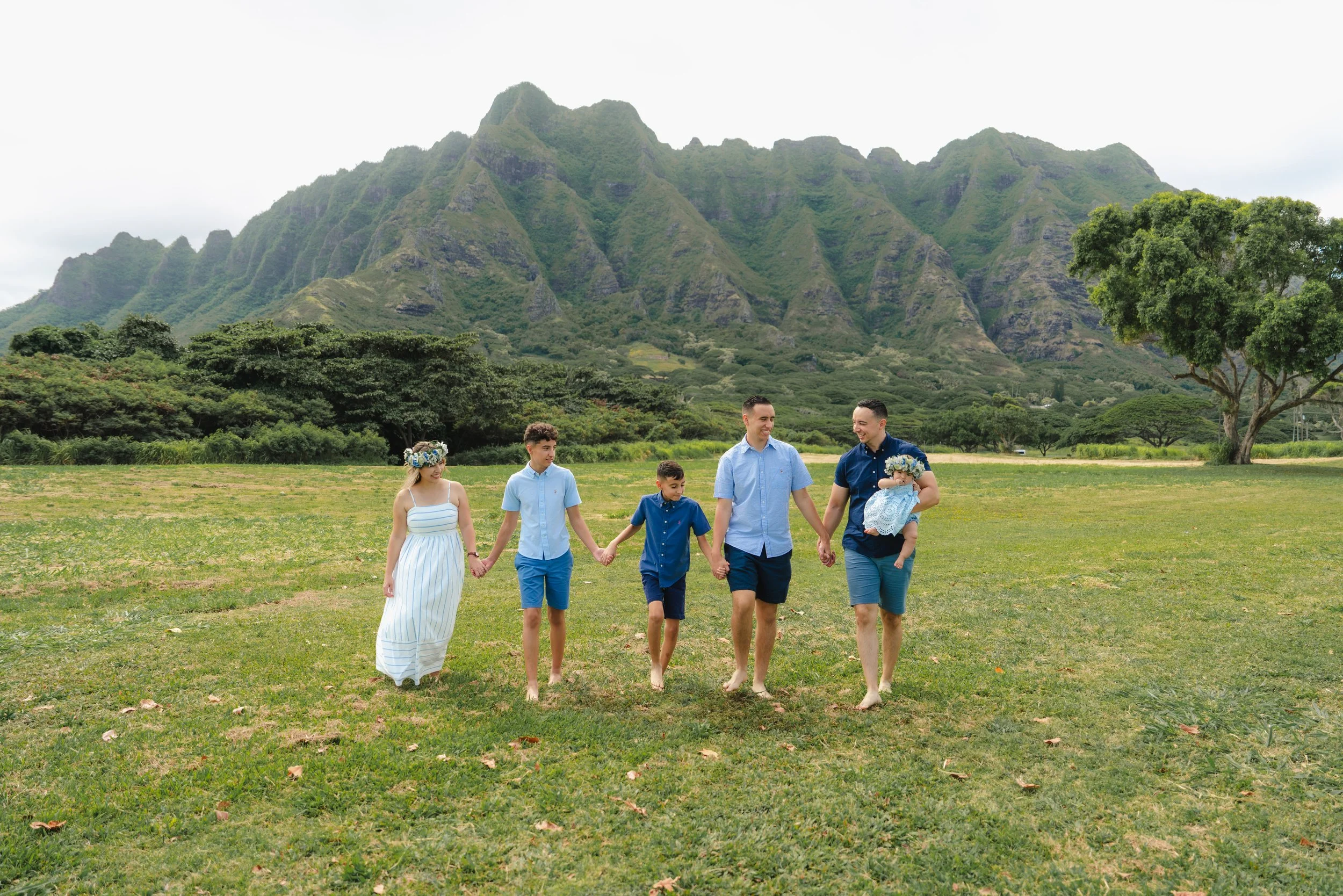 Family portrait with their baby surrounded by the dramatic mountains of Kualoa Regional Park on Oahu