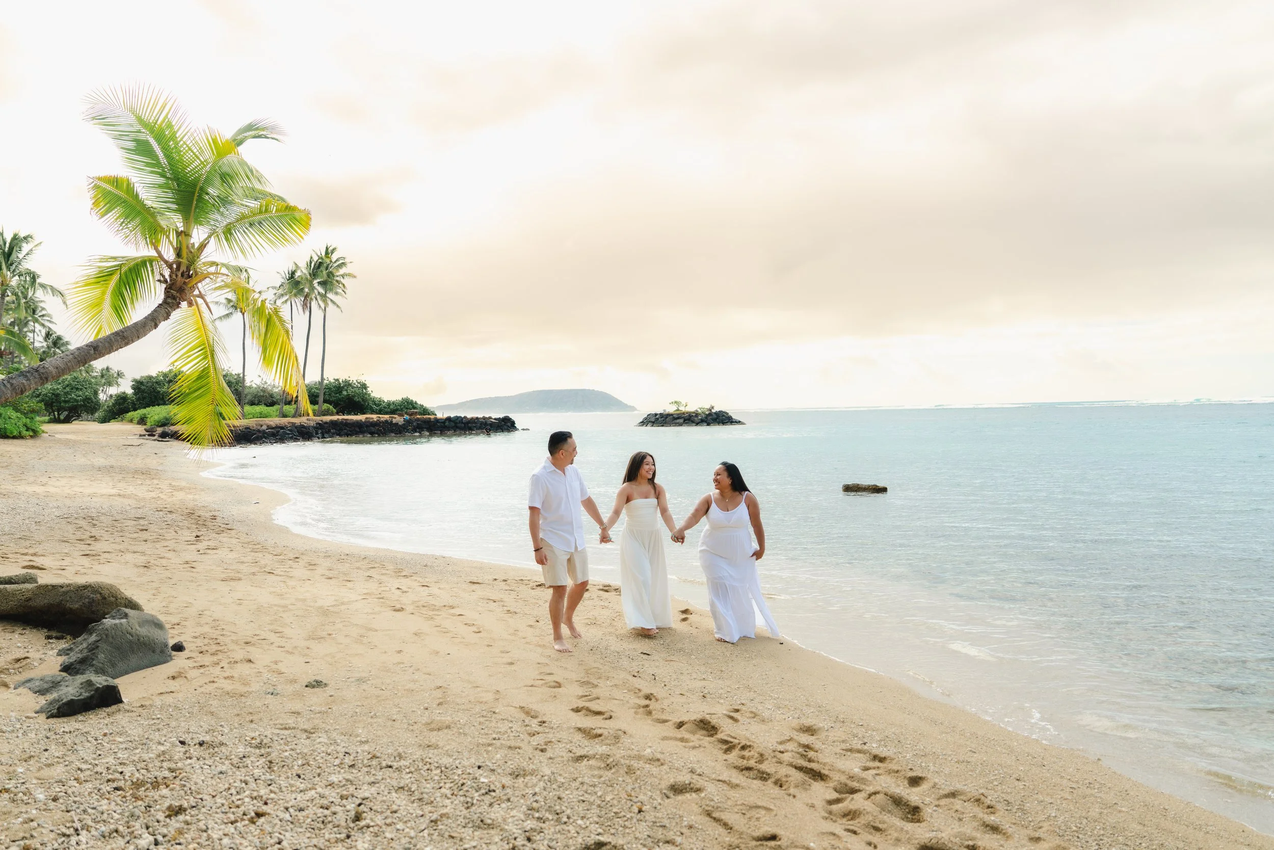 Family enjoying a relaxed sunset beach photoshoot at Kahala Beach on Oahu