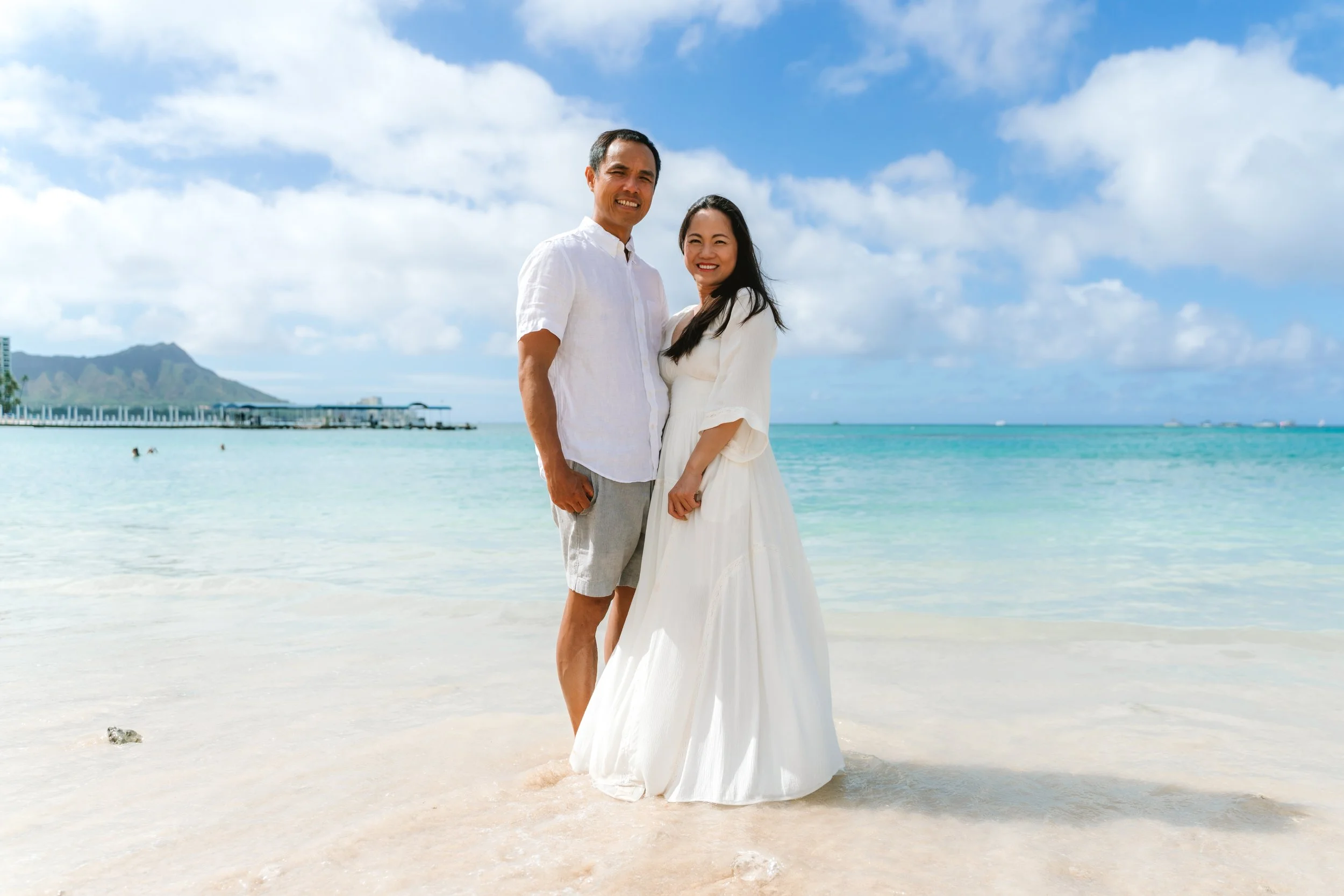 Couple enjoying a sunset walk by the ocean during an Oahu couples photography session at Waikiki Beach.