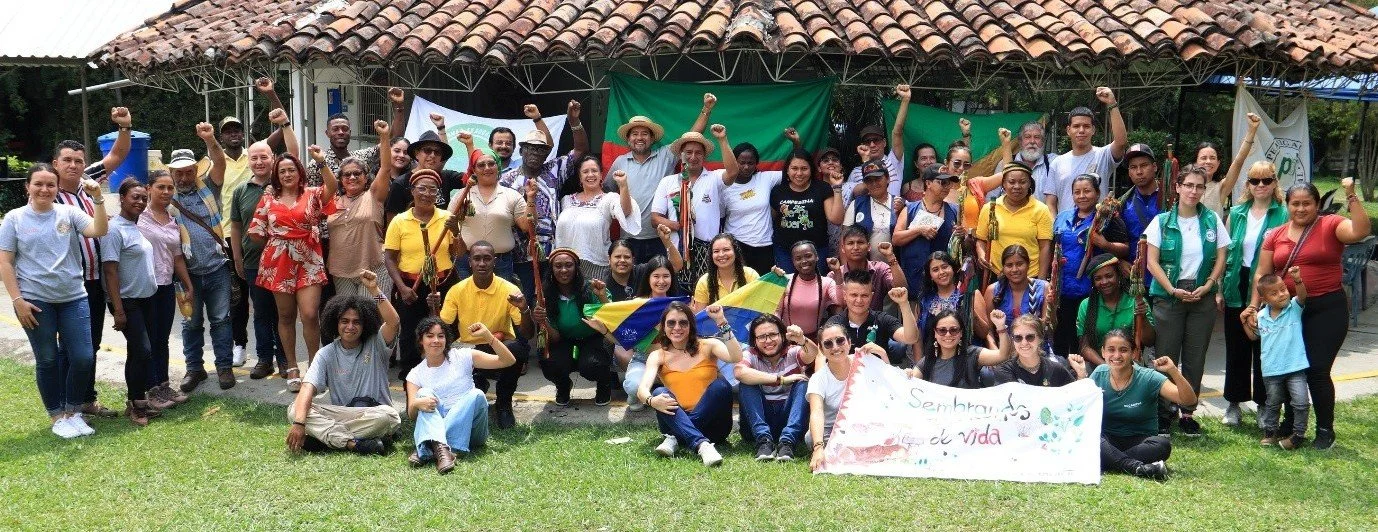 Group of community members showing posing for a photo with fists raised in solidarity.