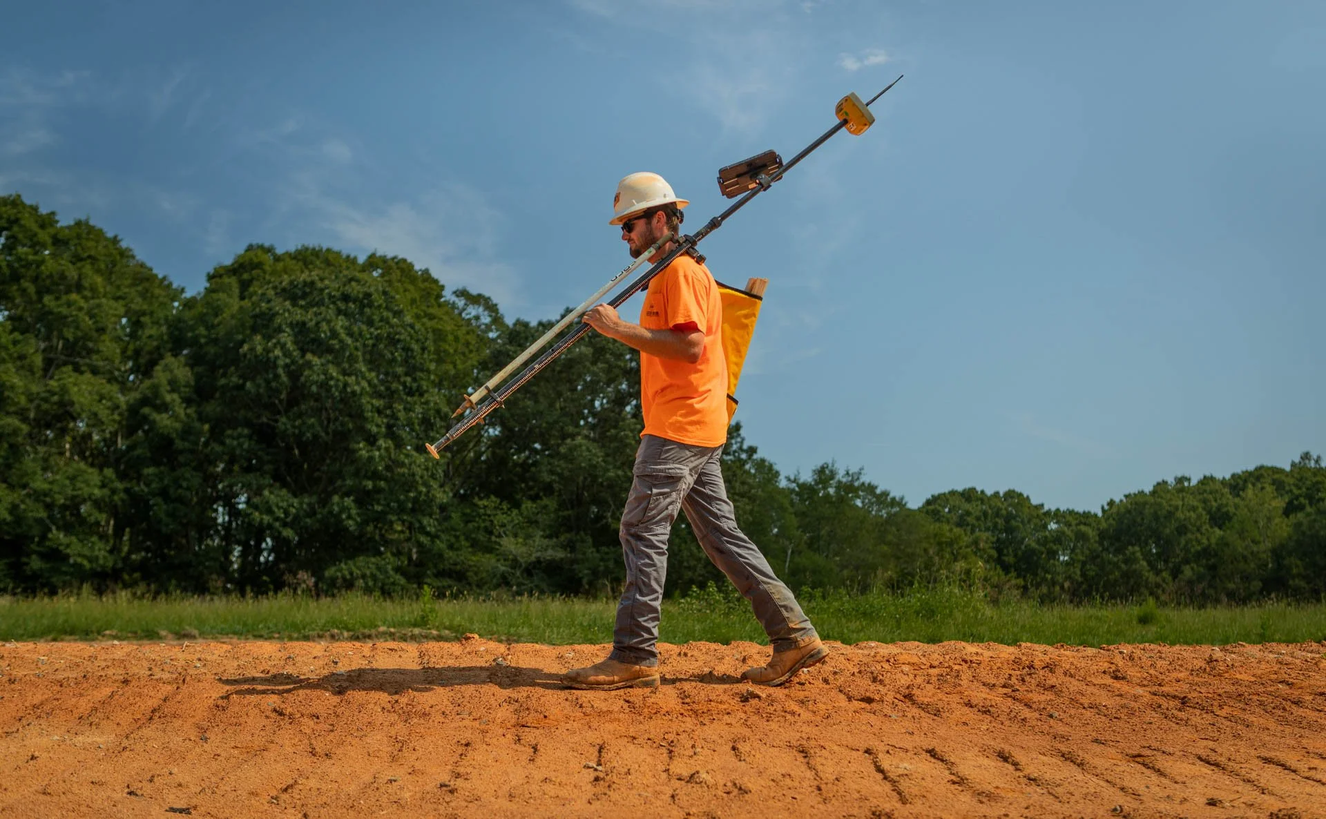 Construction surveyor carrying GPS equipment at Lassiter Taylor Construction site in Greenville, South Carolina — commercial construction photography by Weaver Media