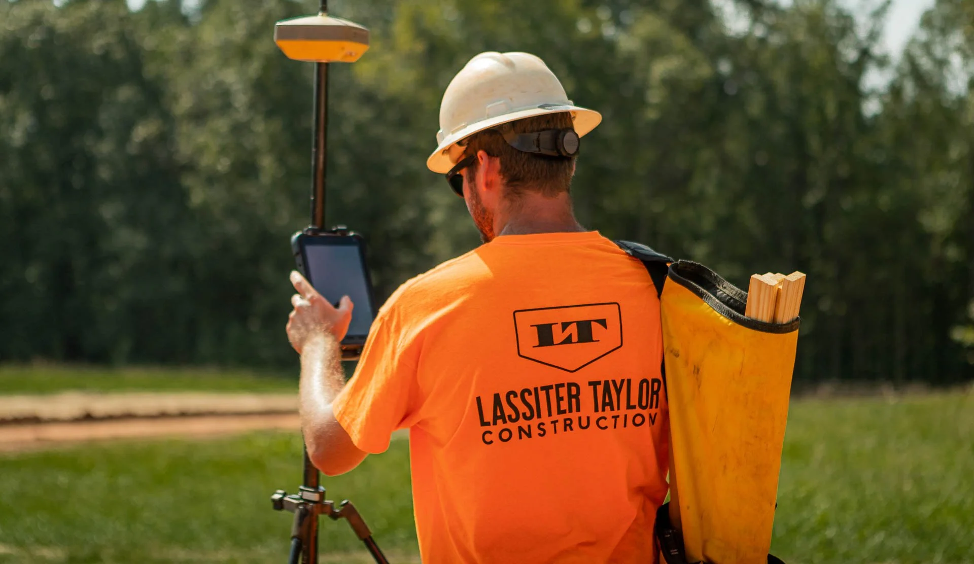 Construction worker using Topcon GPS surveying equipment on a Lassiter Taylor Construction job site in Greenville, SC — construction brand photography by Weaver Media