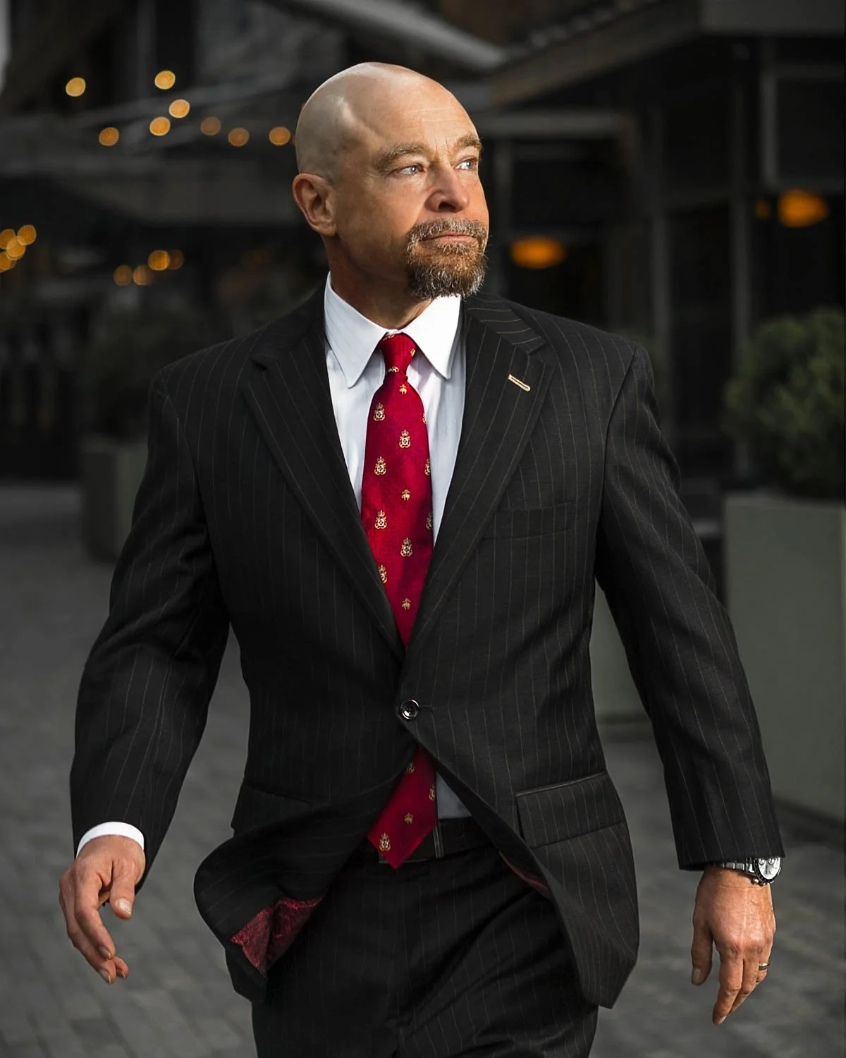 Business attorney Michael Thomerson, managing partner of Thomerson Jones & Edwards P.C. walking through downtown Greenville, South Carolina in pinstripe suit — law firm brand photography by Weaver Media