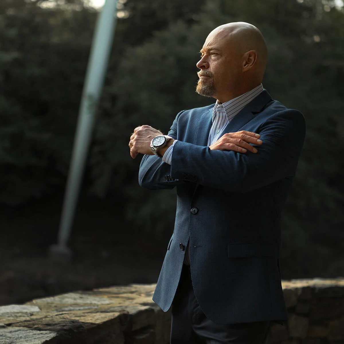 Business attorney Michael Thomerson, managing partner of Thomerson Jones & Edwards P.C. standing in Falls Park in downtown Greenville, South Carolina in a suit — law firm brand photography by Weaver Media.