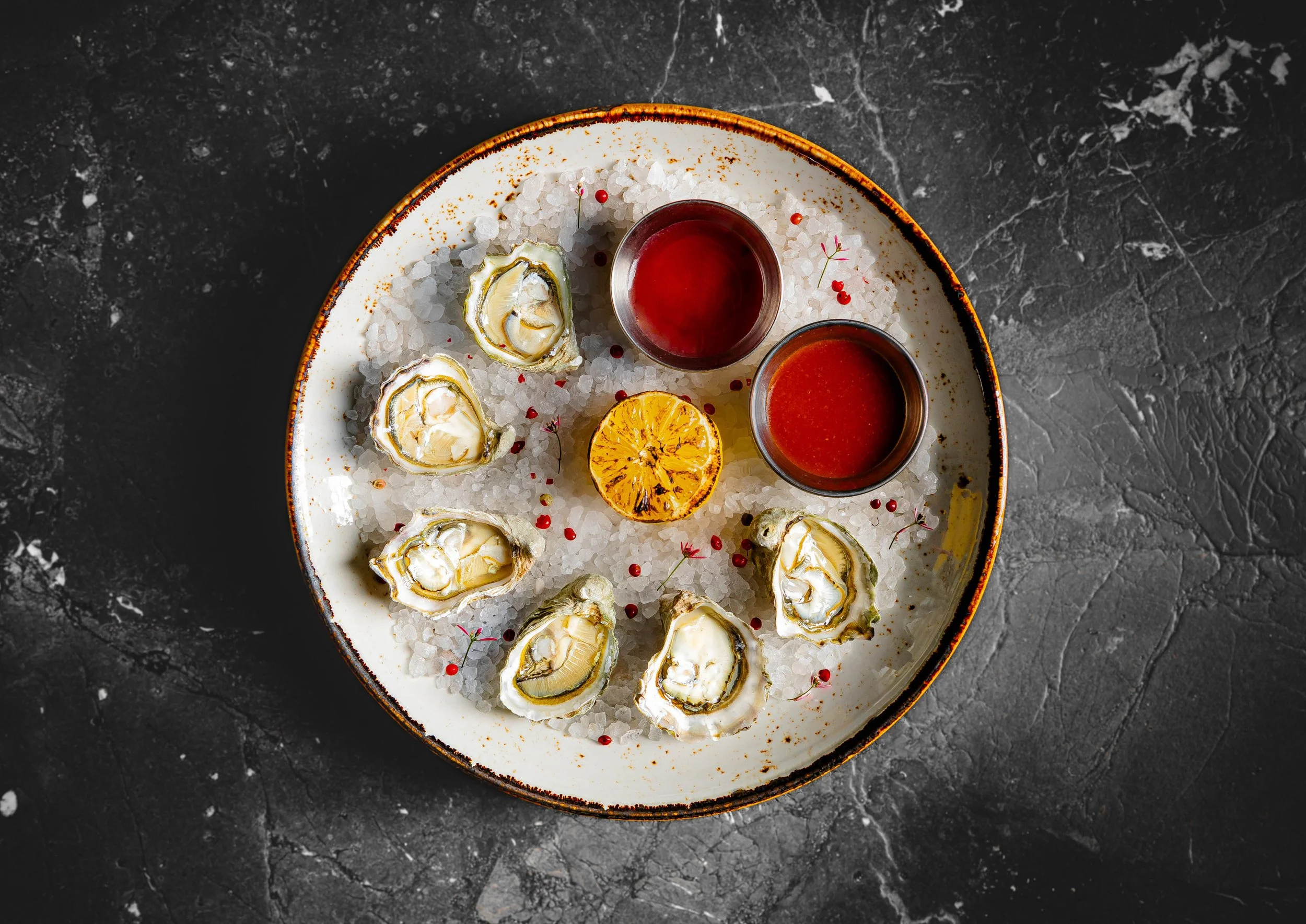 Fresh oysters on ice with charred lemon served at Curean Mediterranean restaurant in Greenville, SC — gourmet seafood photography by Weaver Media