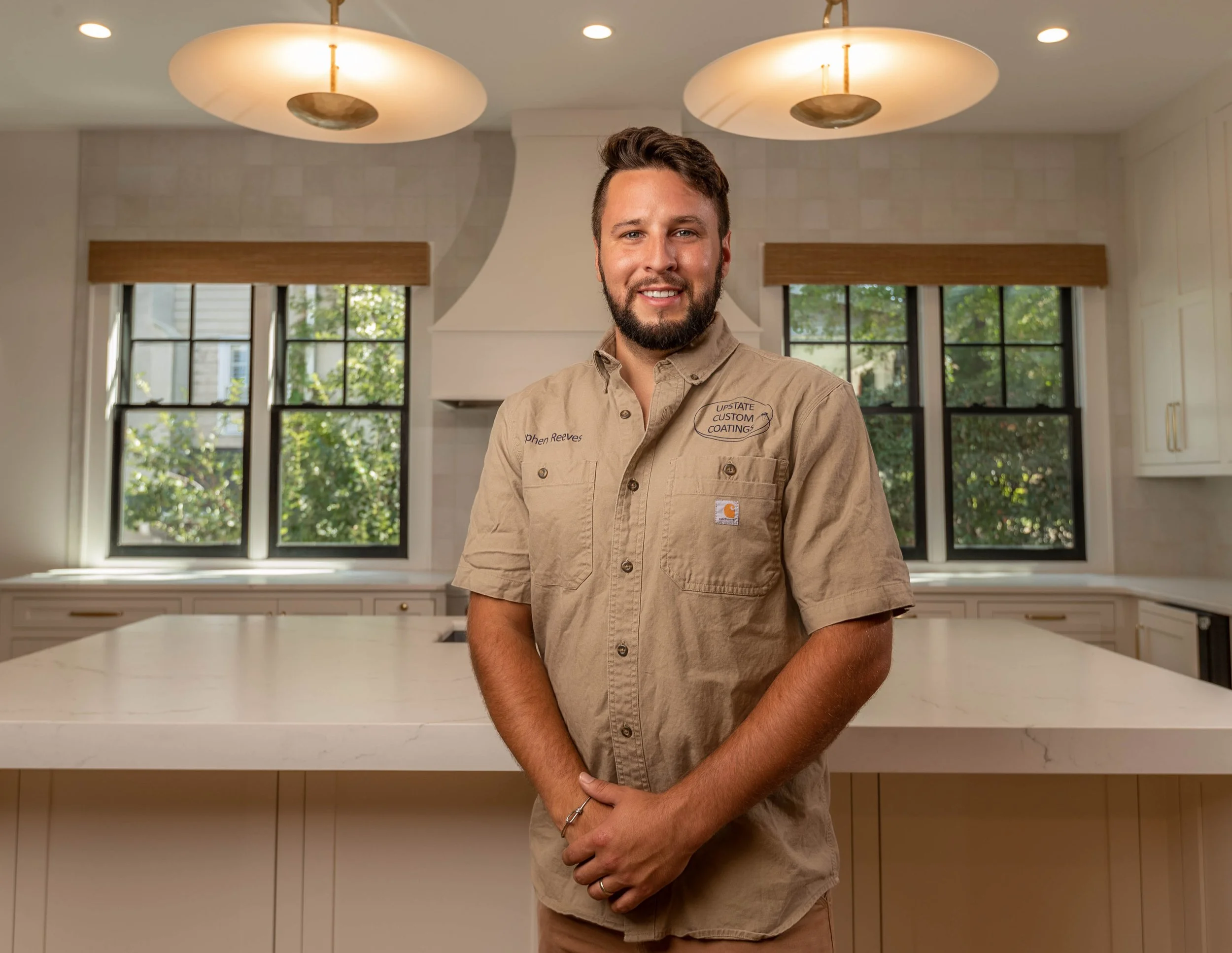 Upstate Custom Coatings owner and CEO, Stephen Reeves standing in modern Greenville, SC kitchen renovation project — residential painting photography by Weaver Media
