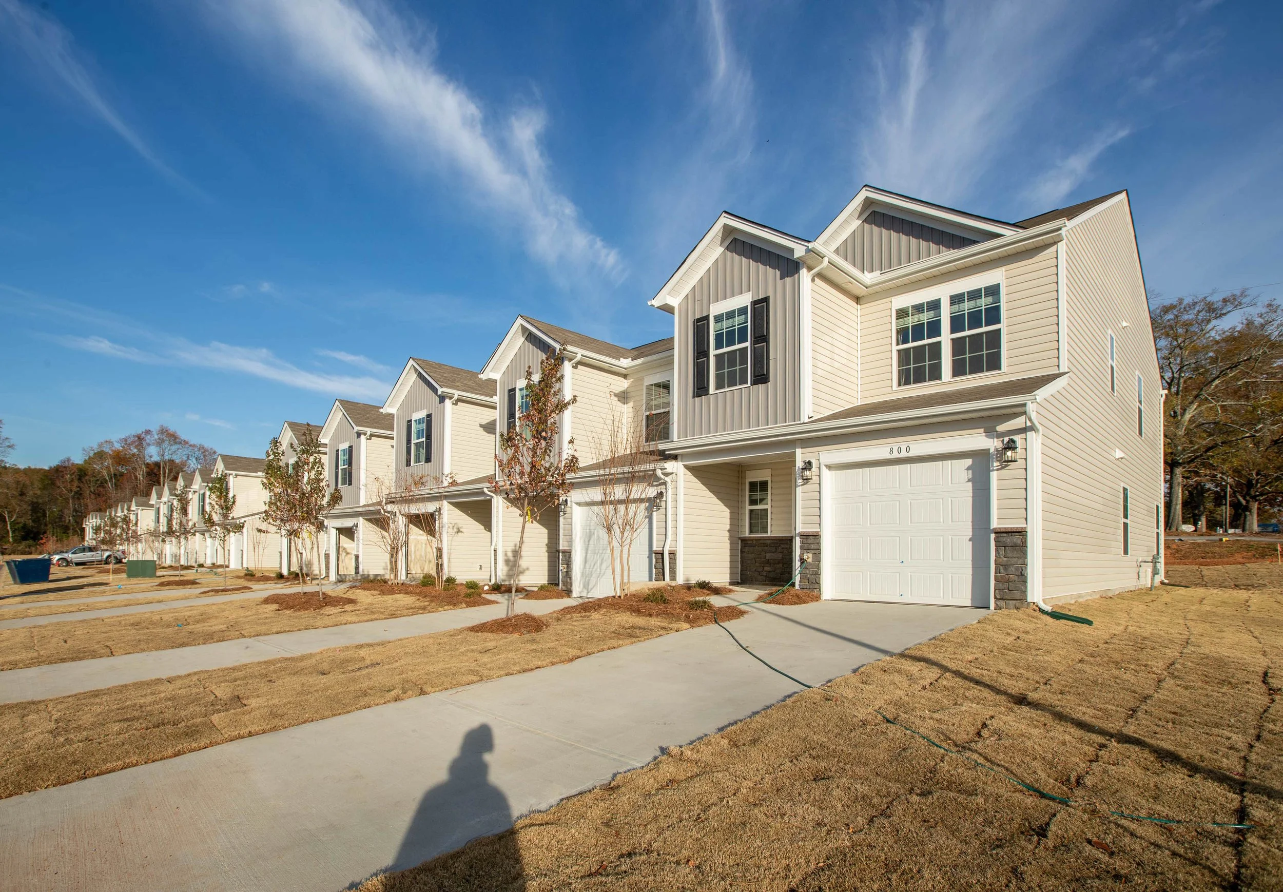 Row of residential townhouses with garages and sidewalks in Greenville, South Carolina — real estate development photography by Weaver Media
