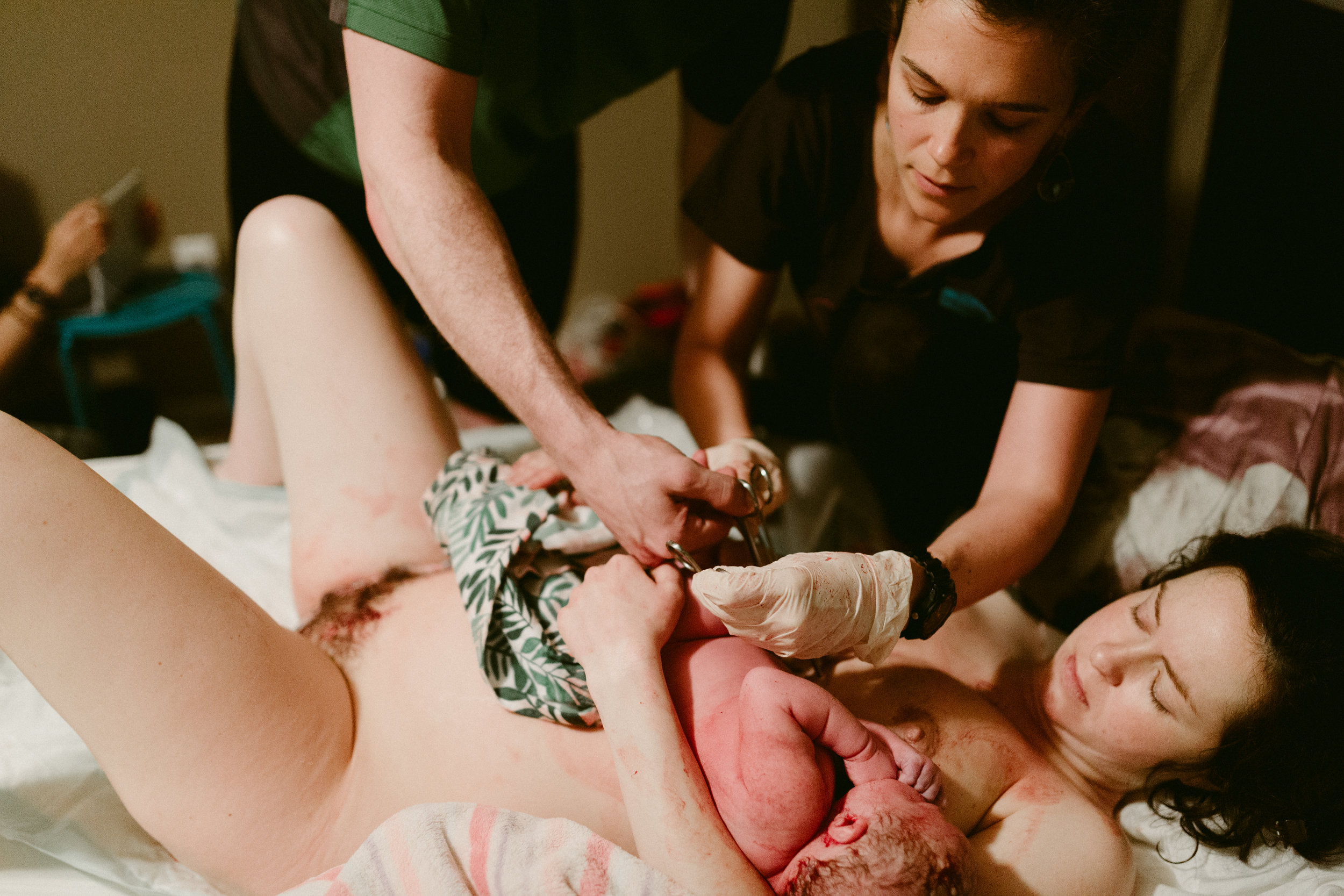 Midwife Lucy French assists a father to cut his newborn baby's umbilical cord.