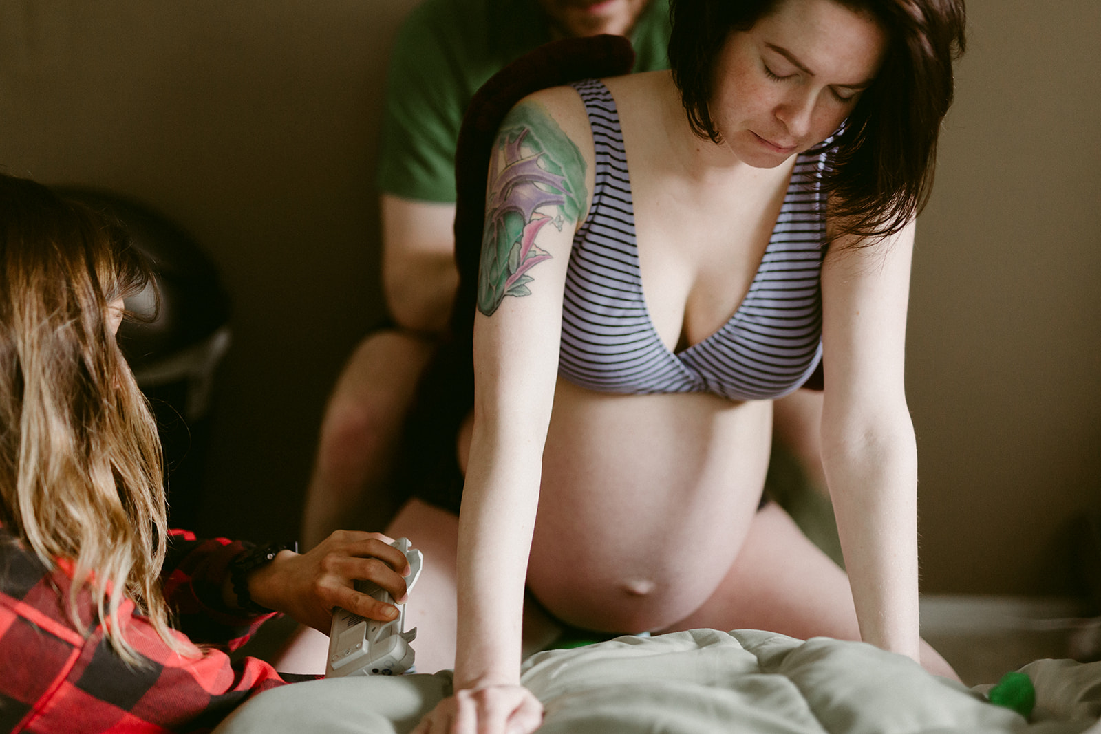 A mother in labor at home with the support of her partner and midwife.