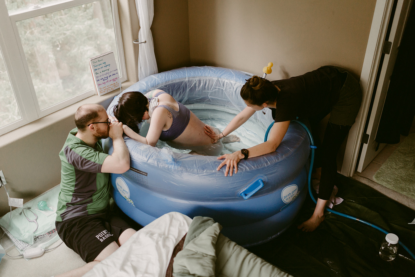 Midwife Lucy French supports a laboring mother in a birthing tub.