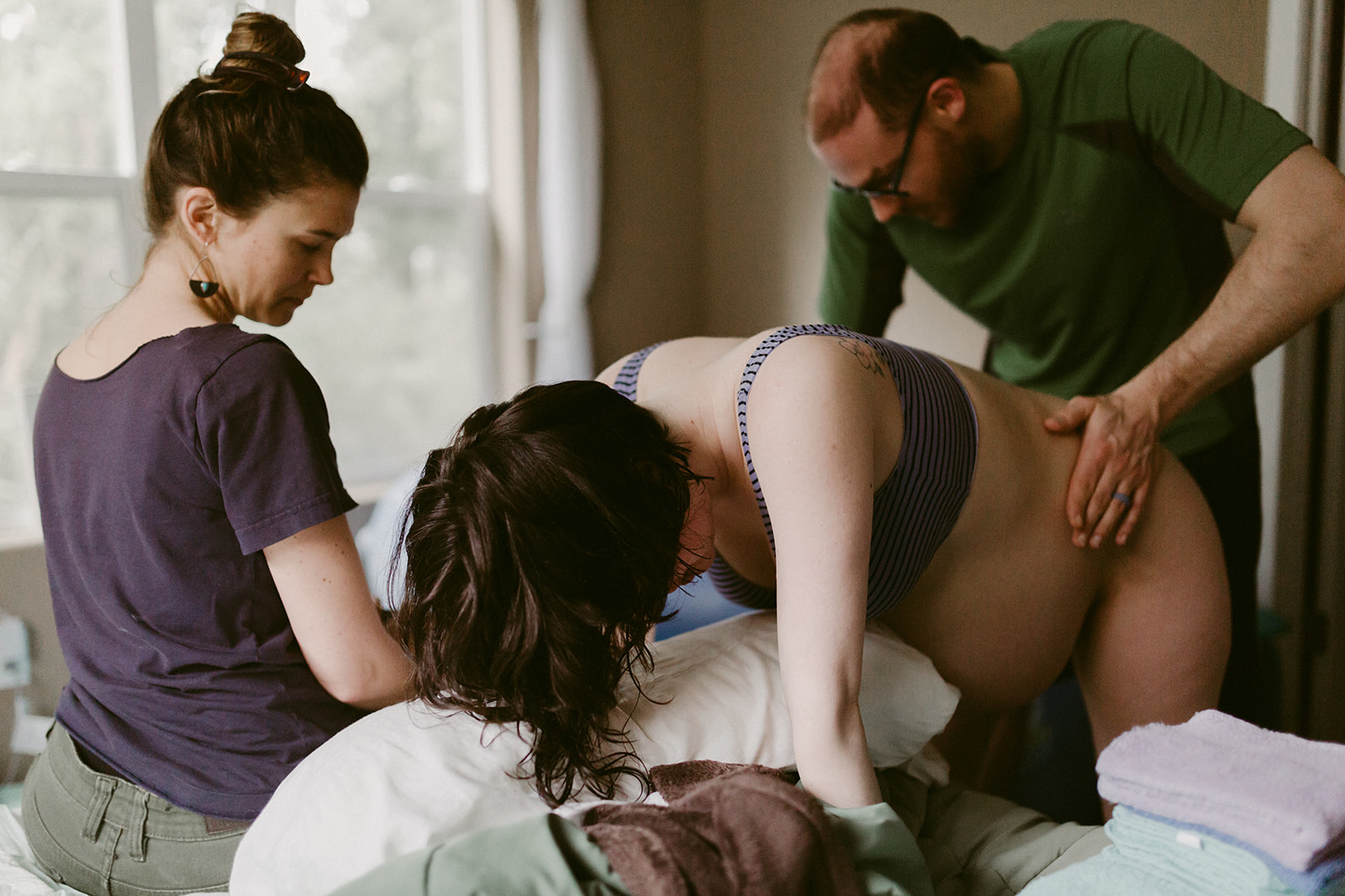 Midwife and partner provide support during a home birth.