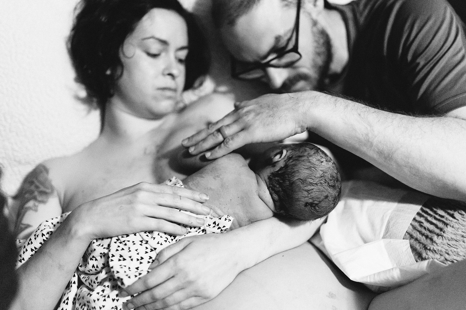Parents greet their newborn baby moments after a home birth.