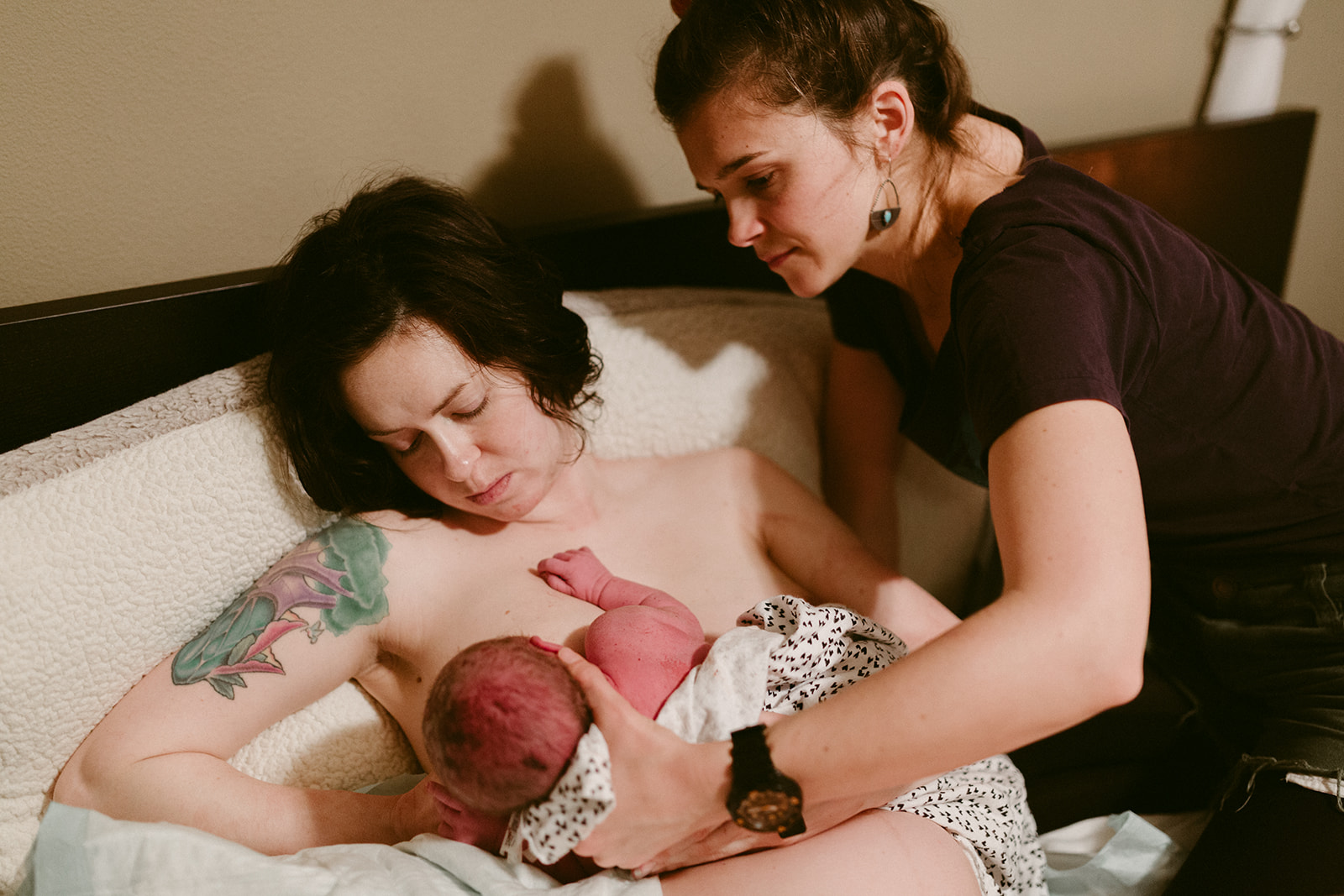 Midwife Lucy French assists a new mother to breastfeed her newborn after a home birth. 