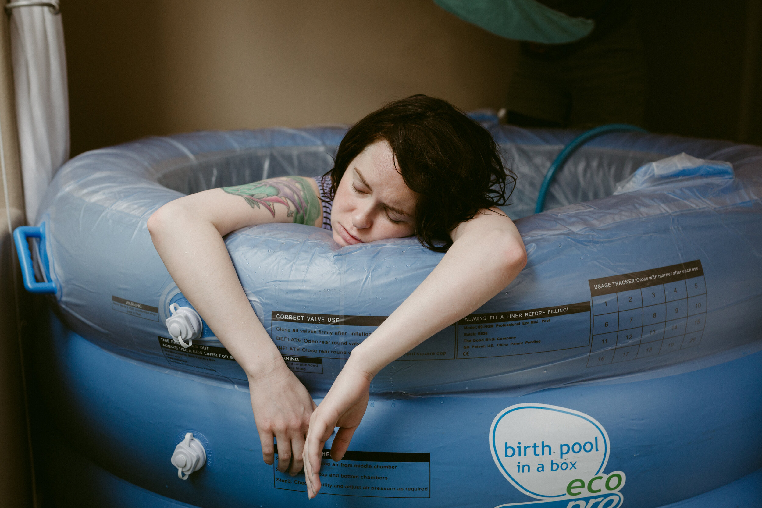 Mother in labor rests between contractions during a midwife assisted water birth.
