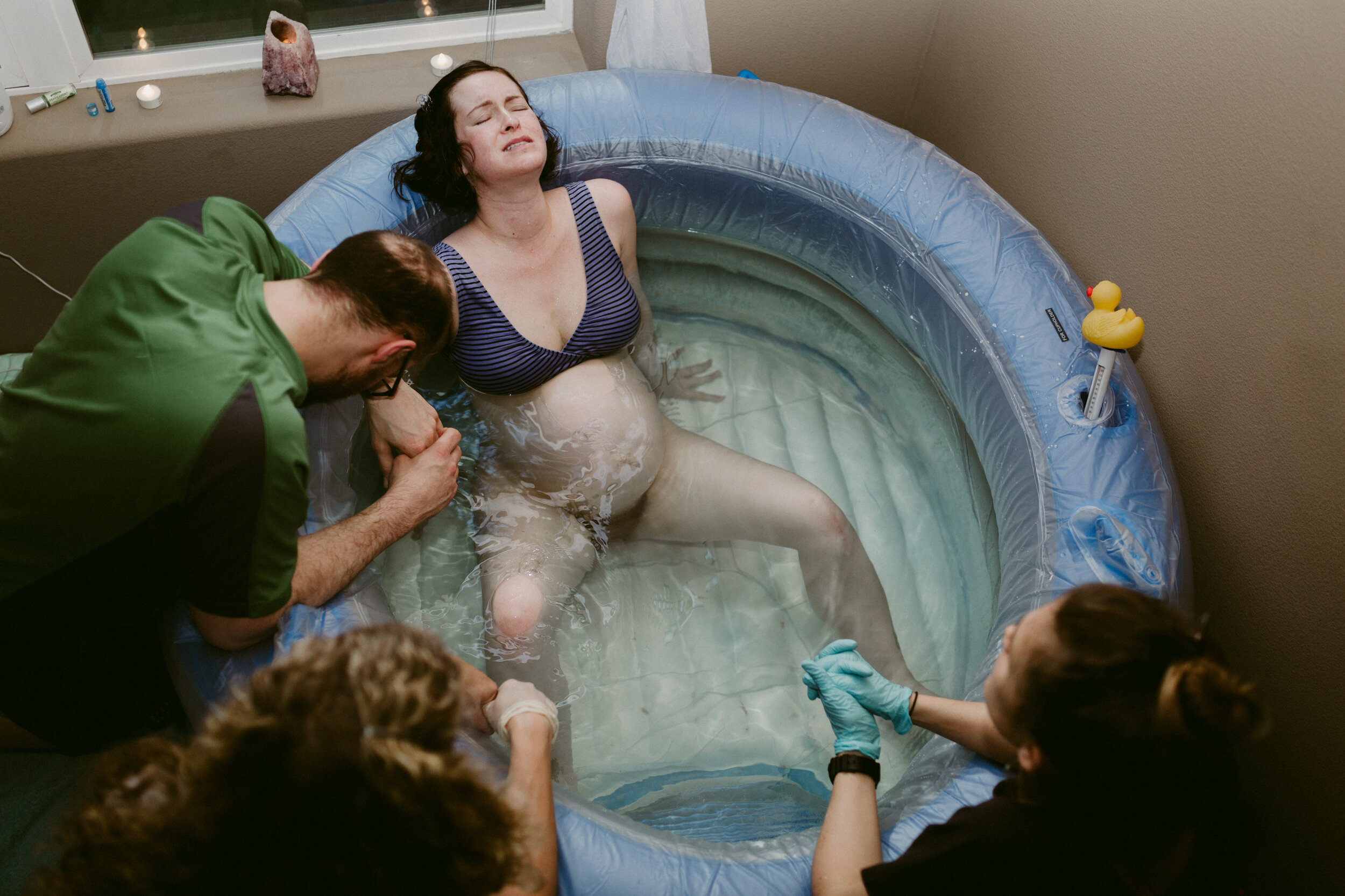 Midwife Lucy French guides a couple through a water birth at home.