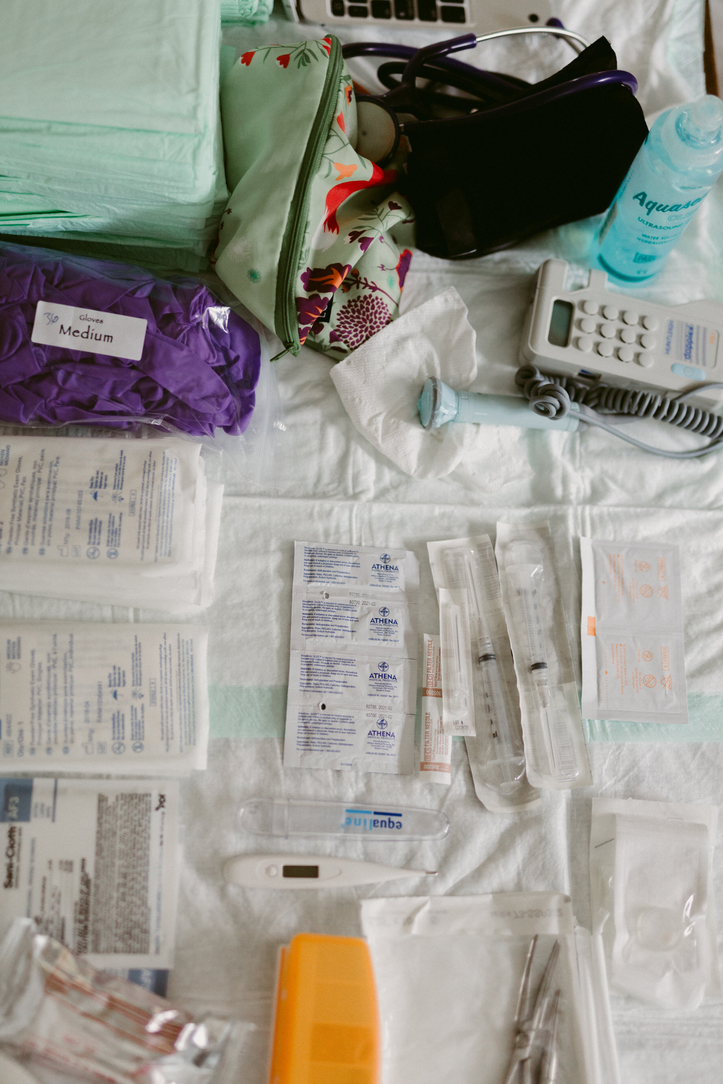 The midwife has laid out medical supplies on a sterile surface in preparation for a home birth.