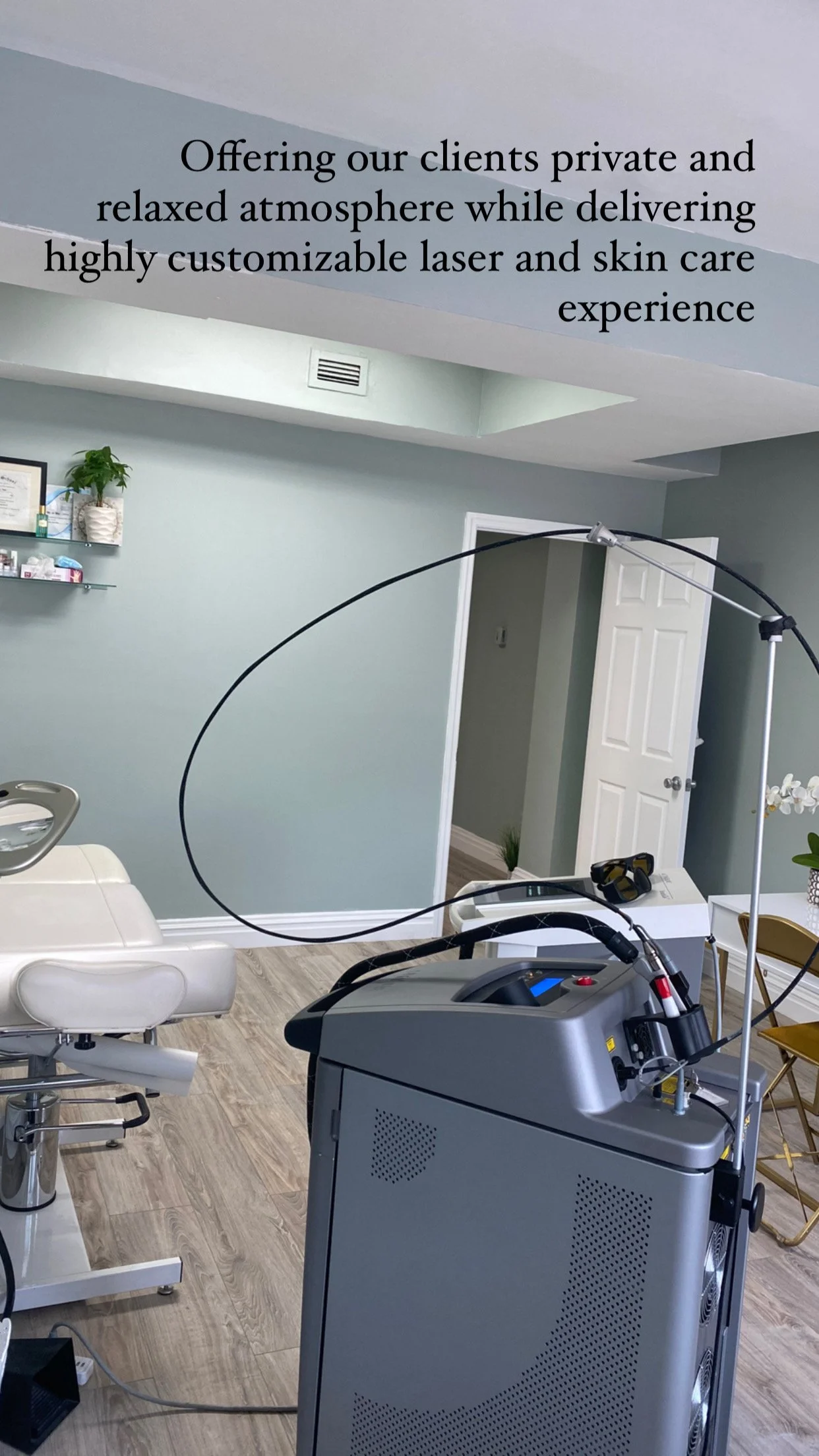 Laser and skincare treatment room with equipment, chair, and calming decor.
