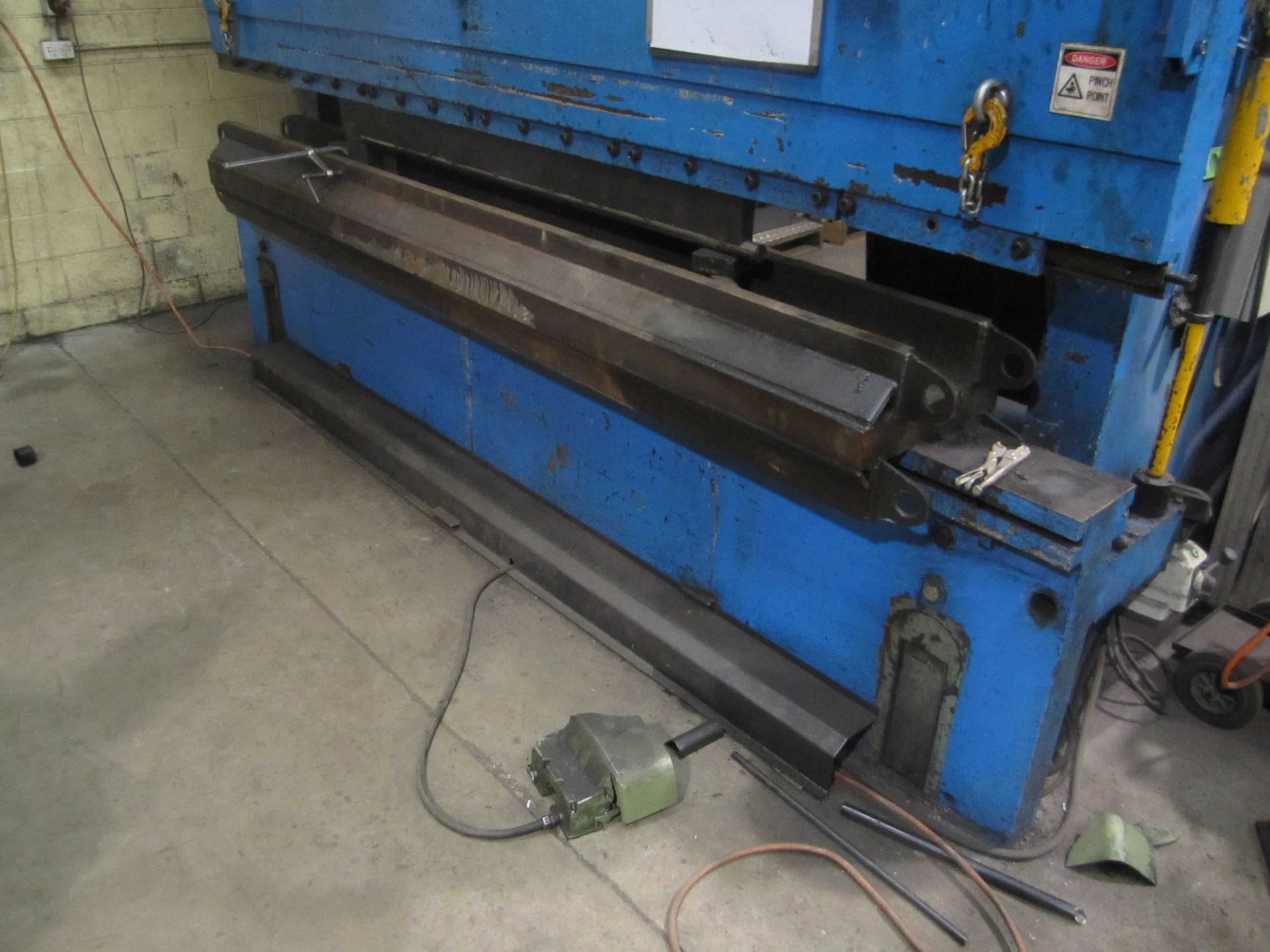 Industrial sheet metal bending machine in a workshop.