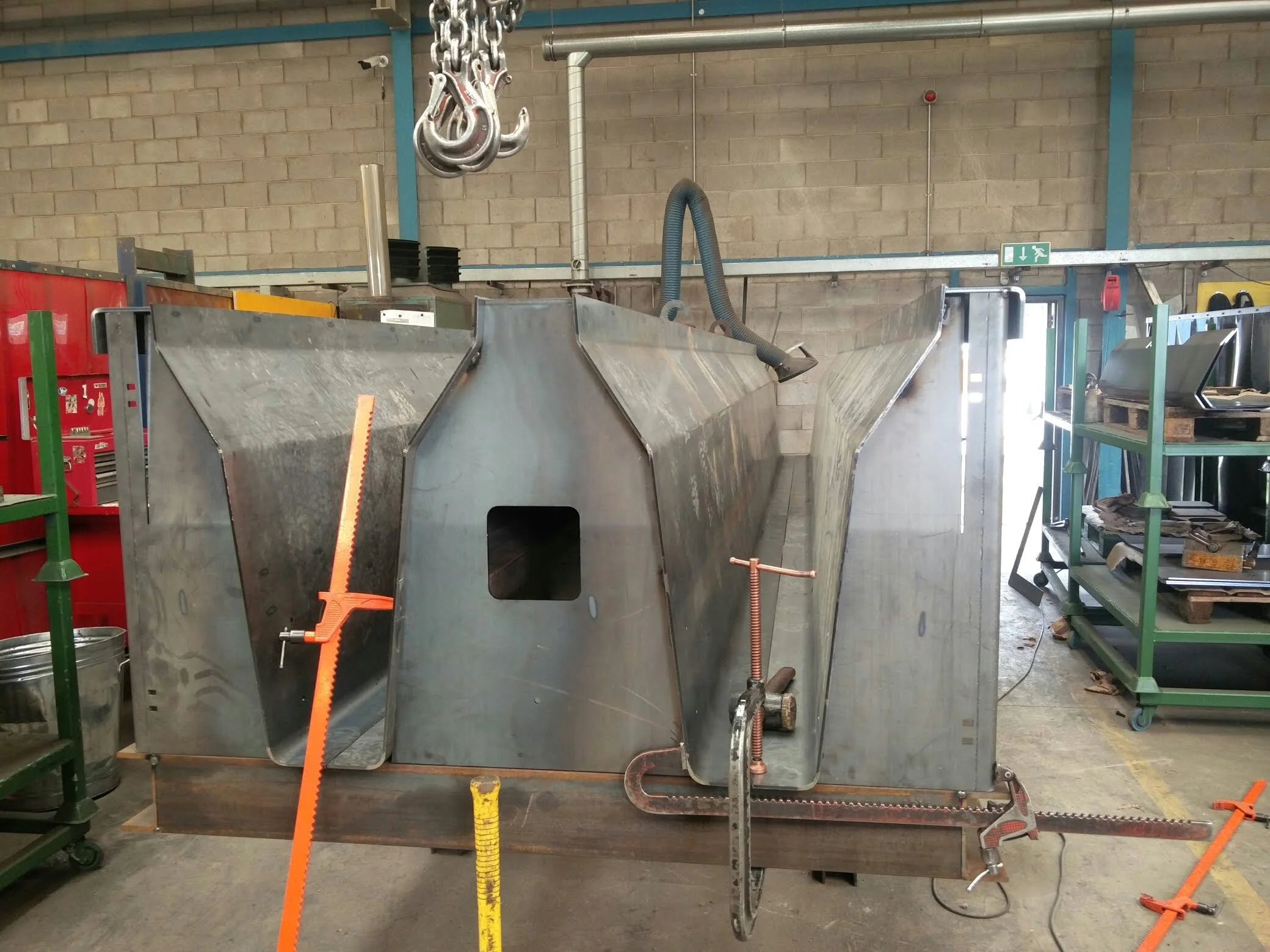 Large metal fabrication with industrial tools in a workshop setting.