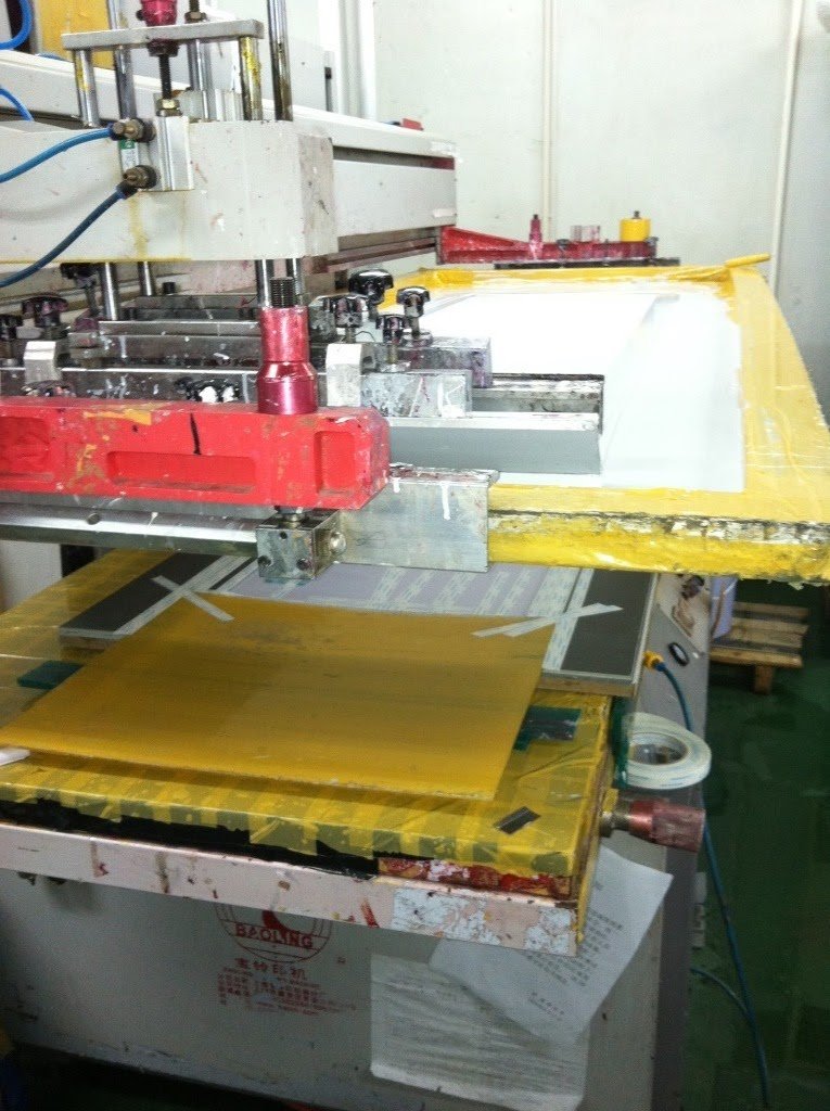 Industrial machine with yellow and white surfaces, used for manufacturing or processing materials.