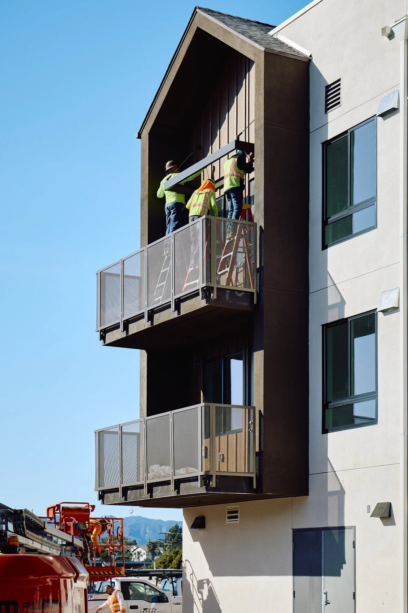 Workers installing cladding on a commercial building, San Diego, California 