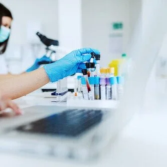 person-entering-data-from-blood-samples-into-laptop-in-lab.jpg