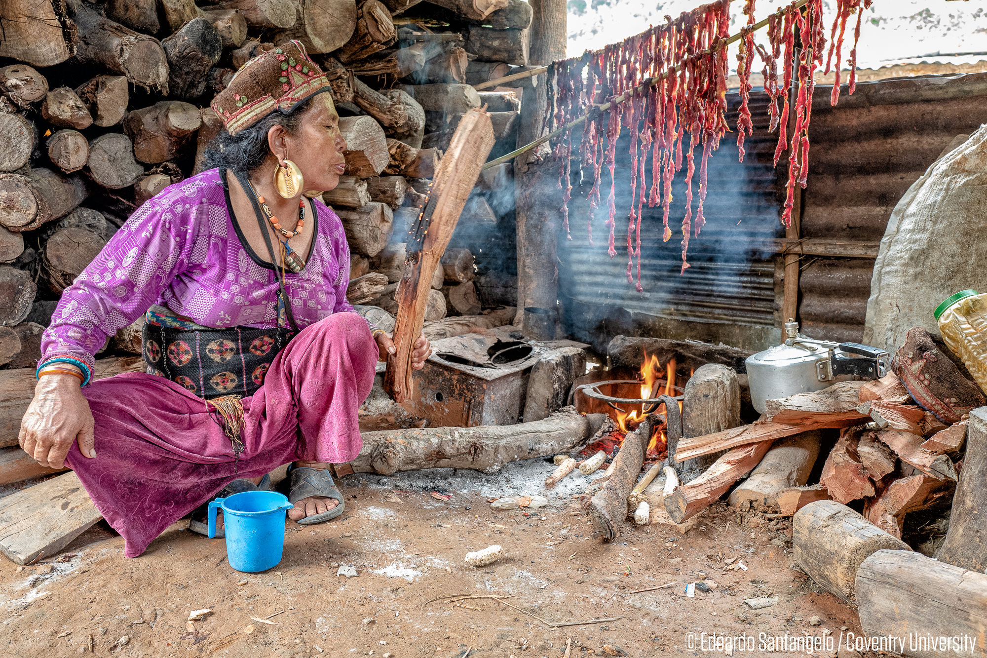 The embers and the meat - Khalte, NepalPooja extinguishing the fire she used to dry and smoke buffalo meat. Although the majority of displaced people have access to LPG stoves, they often prefer cooking with firewood nevertheless to enhance the flav…