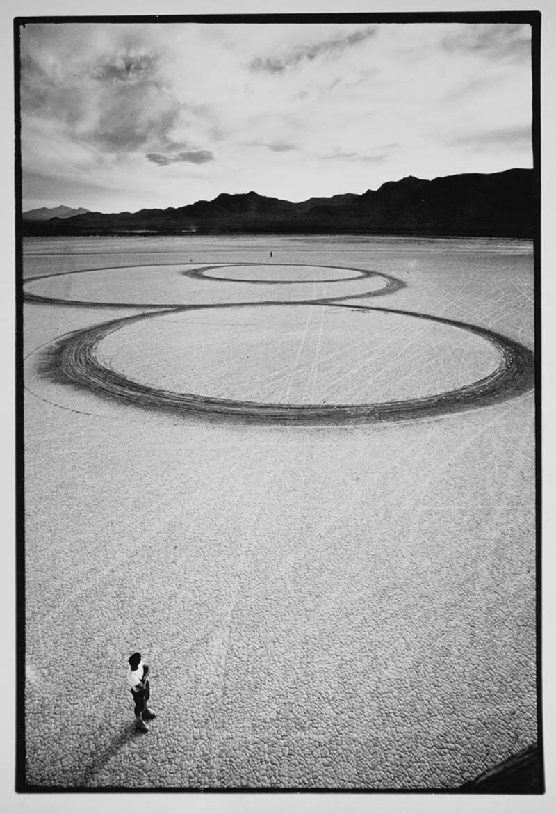 Created by Micheal driving his motorcycle around in circles inJean Dry Lake to create a pattern of lines. The photographers were there to document Heizer’s movement. The cameras were strapped to a twenty four foot scaffold that was moved sixteen fee…