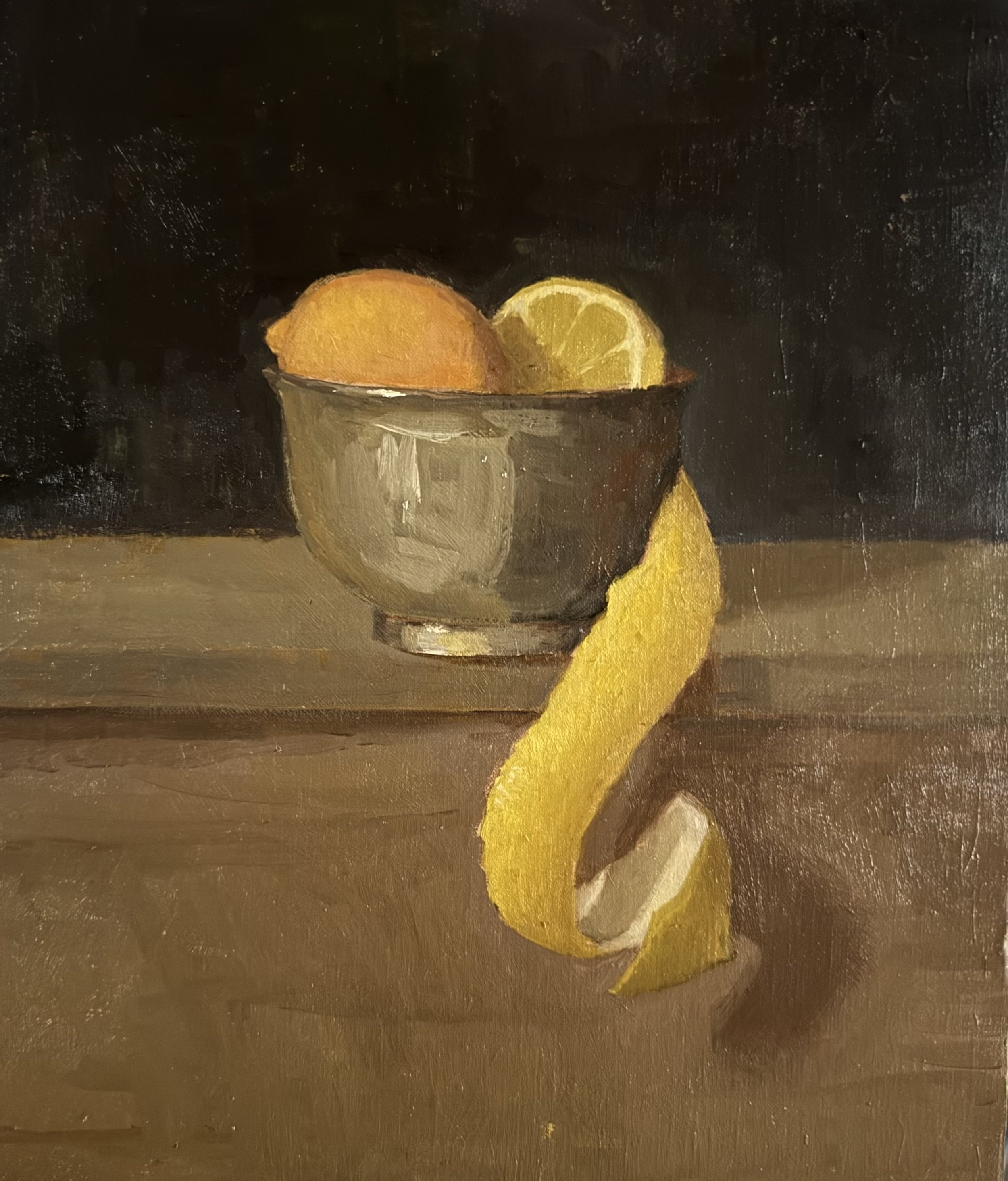 Oil painting of a metallic bowl with a lemon half and a whole lemon inside, on a wooden surface, with a lemon peel draped over the edge and lying on the table in front, against a black background.
