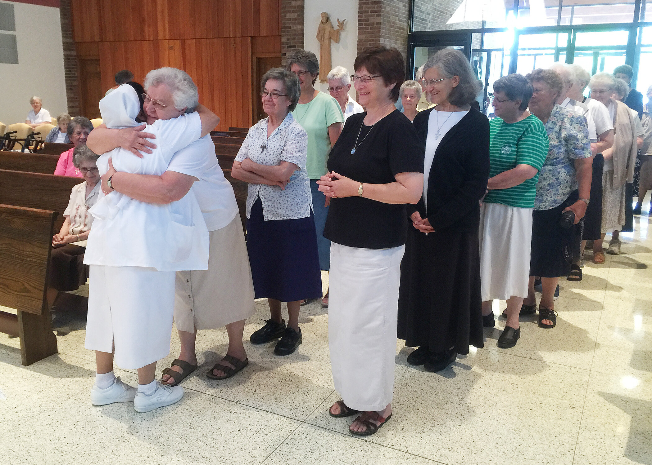  As Sister M. Virginelle Makos offers an embrace, other Sisters wait to personally welcome Sister Gracy Kundukulam as a member of the U.S. Province in 2016. 