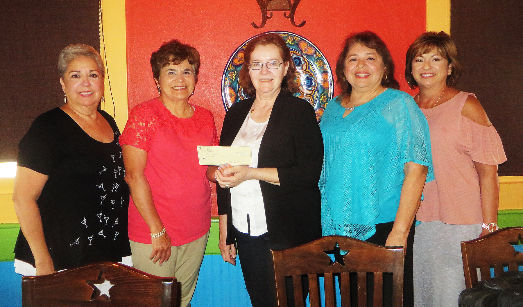  Sister Jo Goolish (center) accepts a donation from the St. Francis Academy Alumnae Association in San Antonio, Texas. 