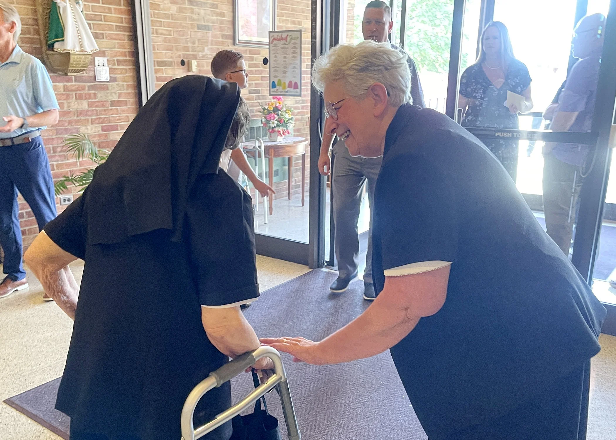  Sister Marian Sgriccia, provincial minister, congratulates Sister Cecilia Jacko before the start of her 75th Jubilee Mass on July 13, 2024. 