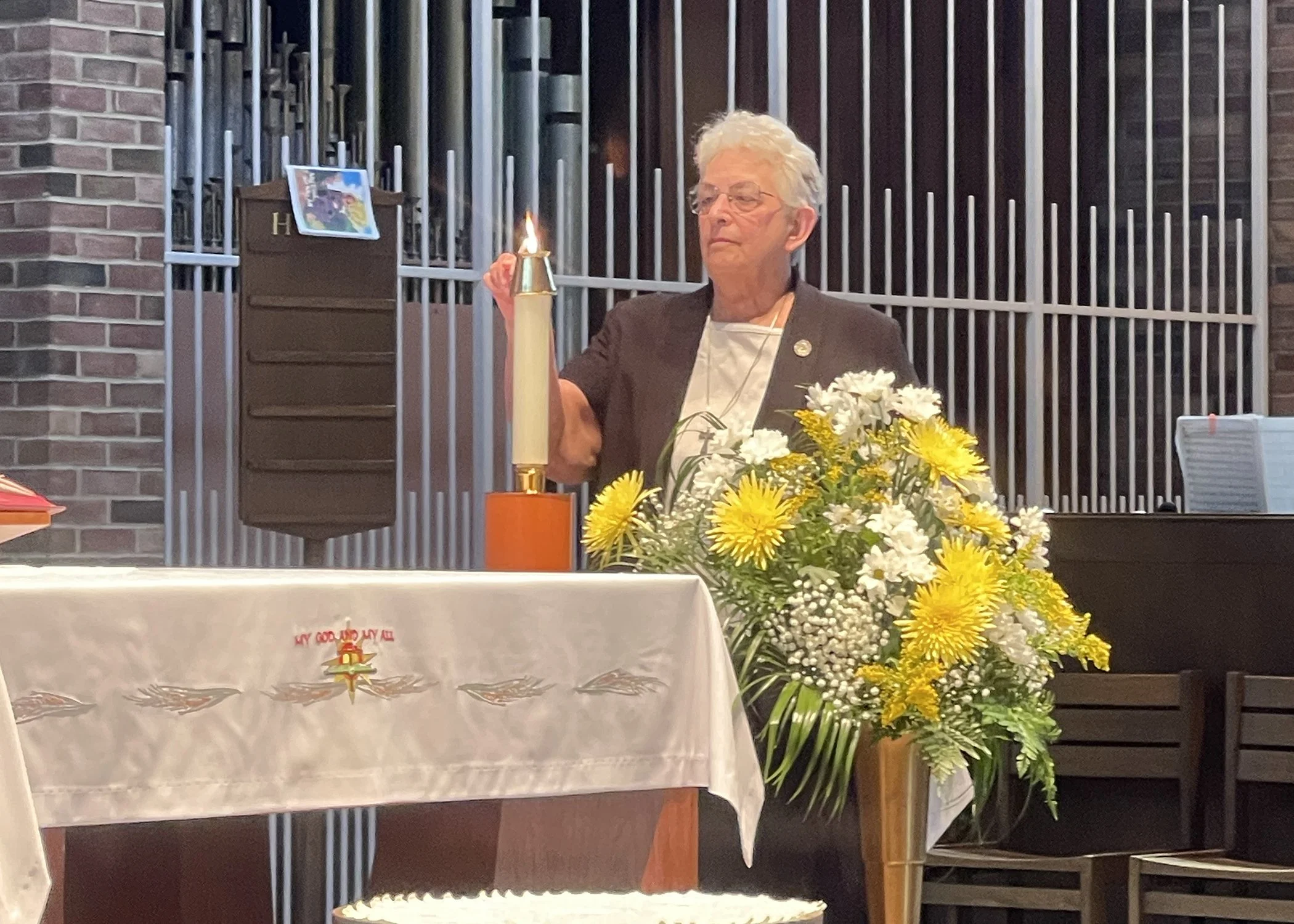  Sister Marian Sgriccia, provincial minister of the School Sisters of St. Francis, lights a candle during the 2024 Jubilee Mass. 