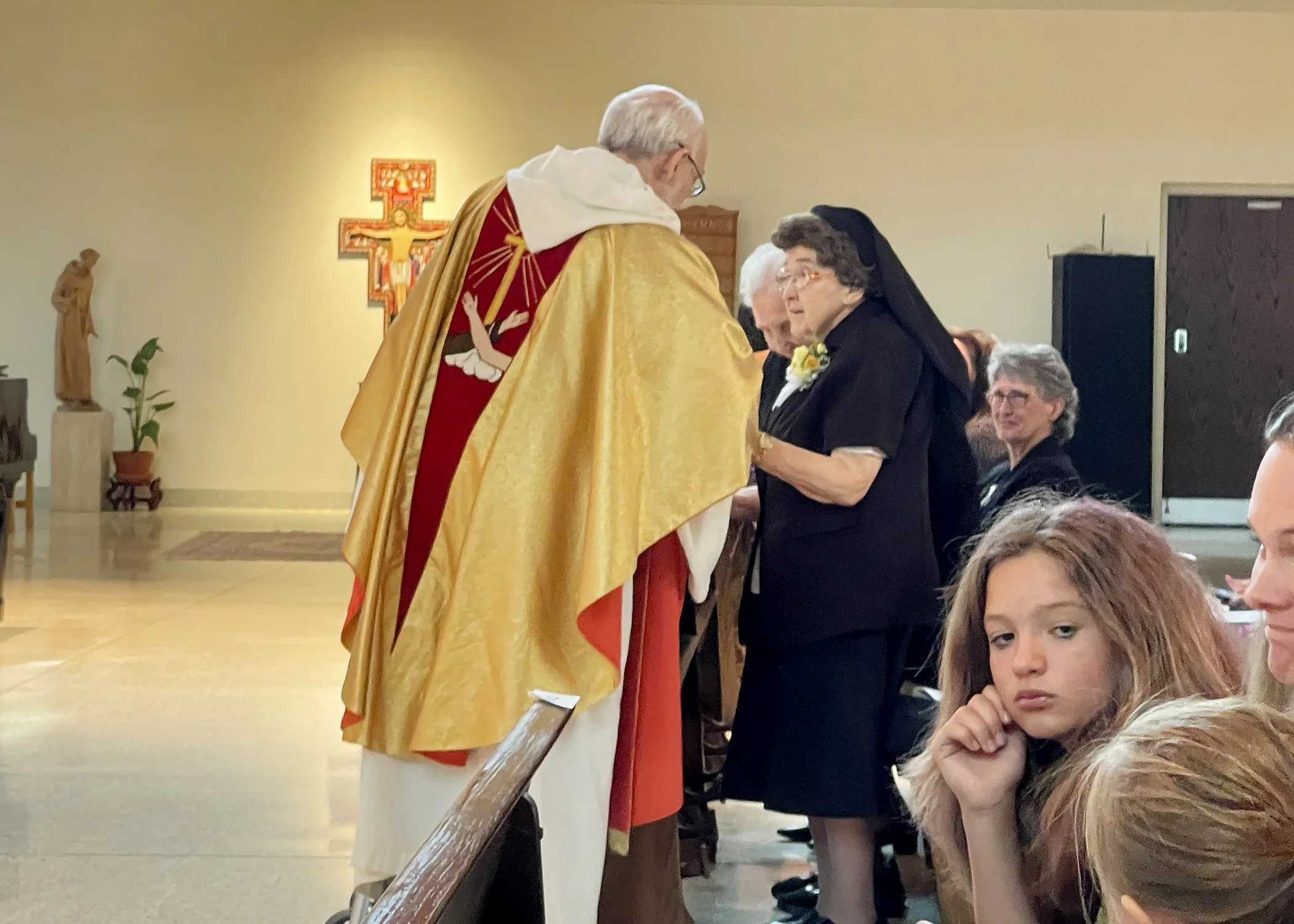  Father Richard Zelik offers blessings to Sister Cecilia Jacko during her 75th Jubilee Mass on July 13, 2024. 