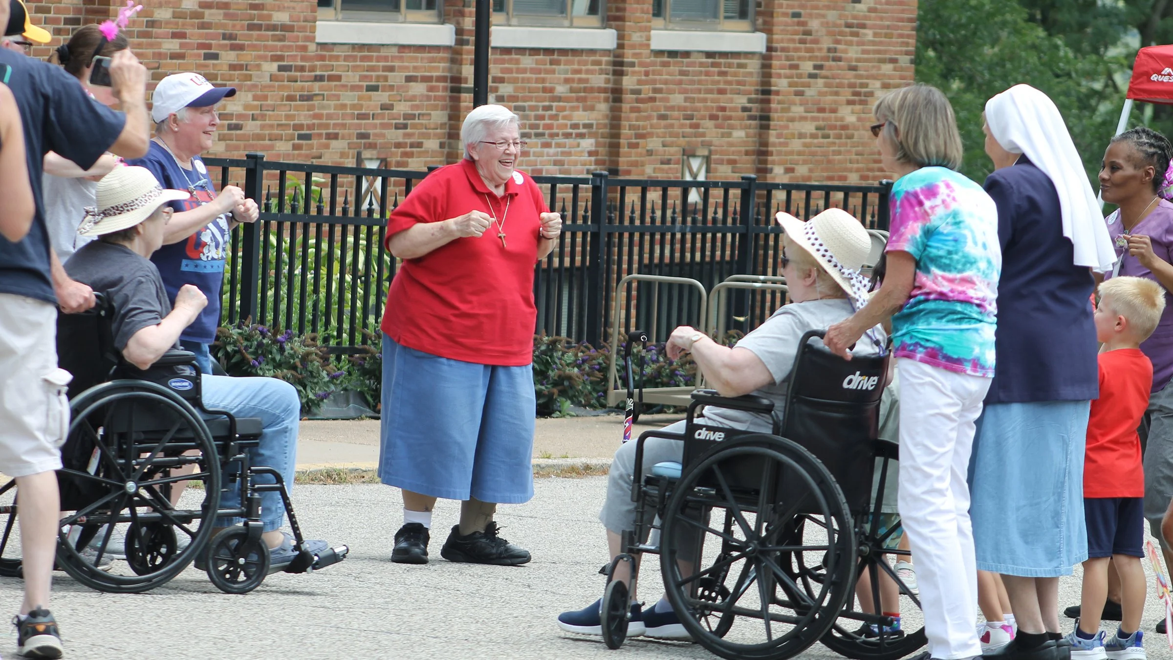  Sister Anece Salay leads a group of residents and family members in the Chicken Dance during Mt. Assisi Place’s Hilltop Olympics &amp; Summer Picnic on July xx, 2024. 