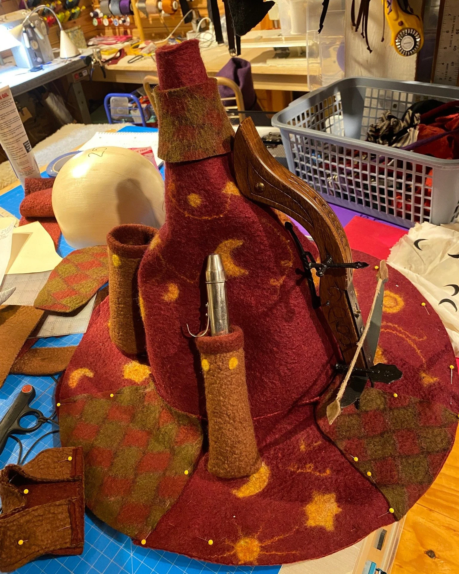 Mustrum Ridcully wizard hat WIP update 3:  The pockets are getting roughed into place and the silver tip of the flask has been sculpted.  I am using goat curls sandwiched between the two layers of the brim and ear flap fur detail.  I am using leather