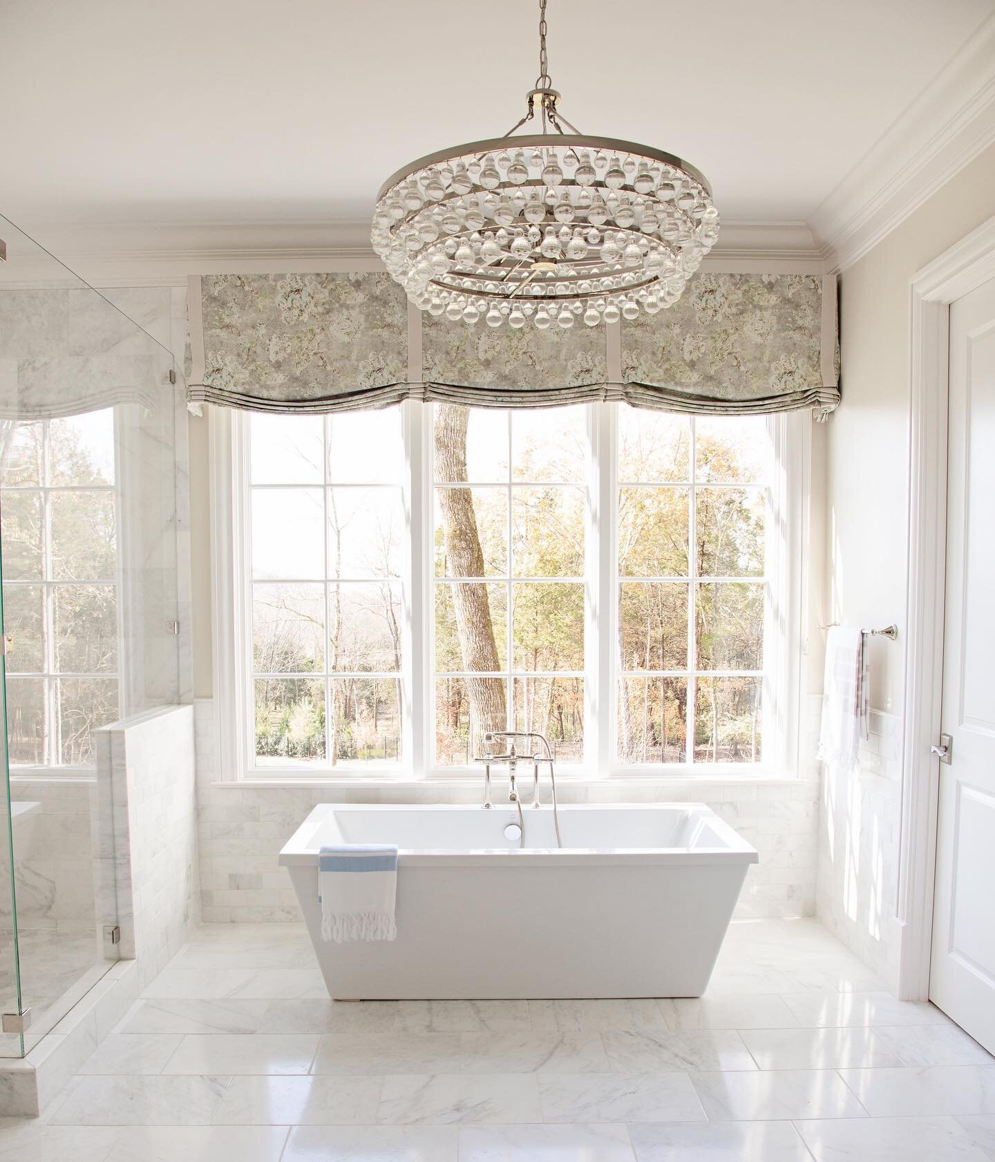 This master bathroom may always be at the top of my favorites list.  Tumbled marble, crystal chandelier, and lots of lot. 🥰. Photo by @kmosleyphotography  #traditionalhome #masterbathroomdesign #marbletile