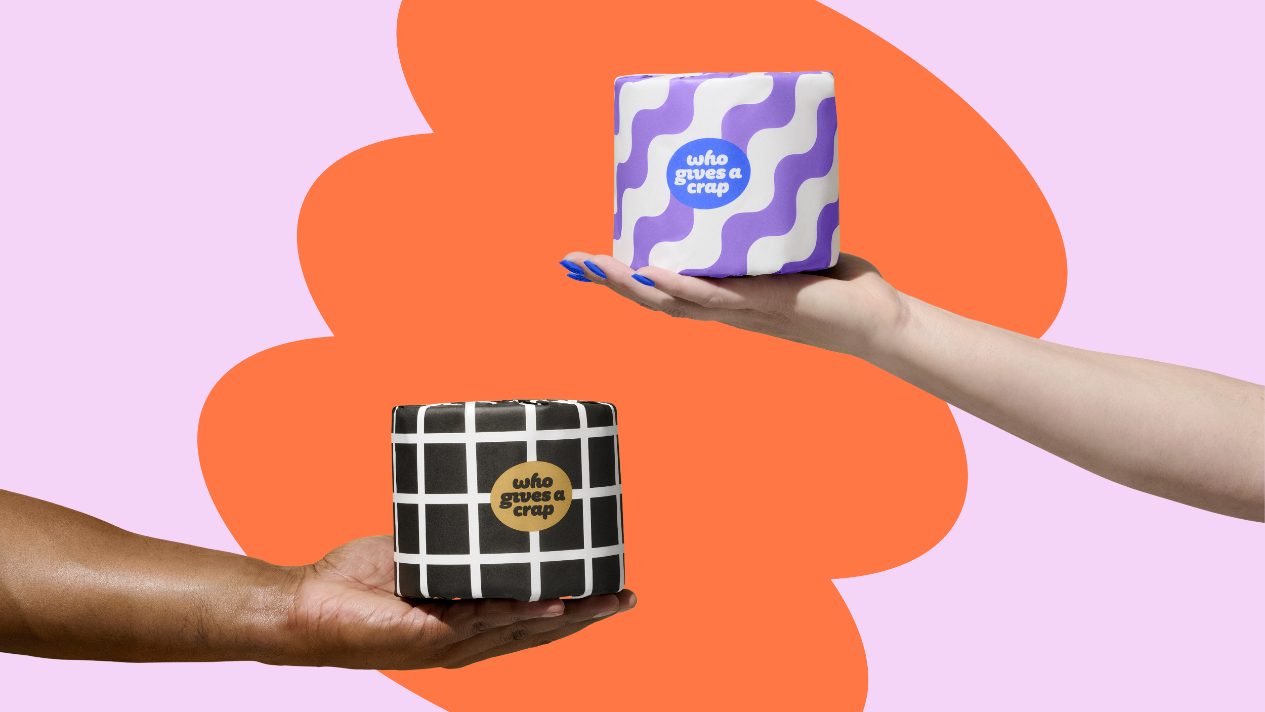 Two hands holding Who Gives A Crap's bamboo and recycled toilet paper rolls.