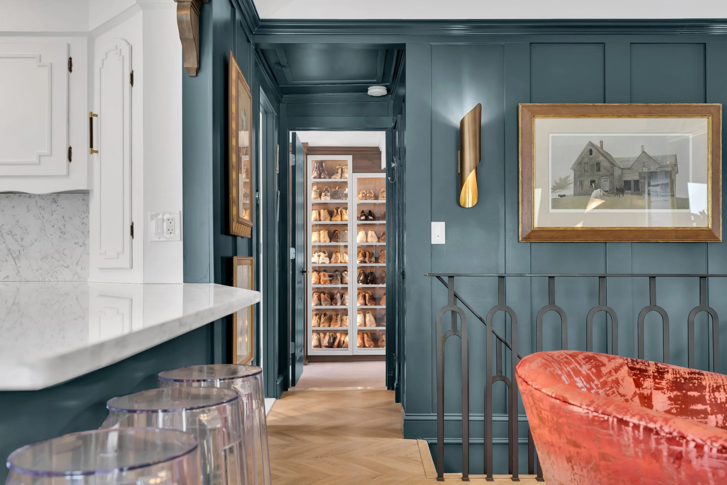 eclectic design of this custom interior includes custom made iron railings, gloss green paneling, sconces from Global Views, custom upholstered chairs, wool area rug, Lucite stools from Phillip Stark, original artwork from Picasso and Andrew Whyte, a