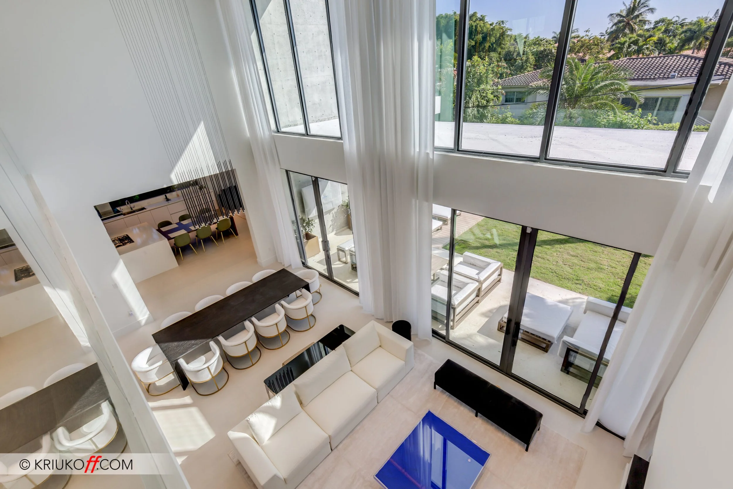 a living room with vast ceiling heights and modern art including a cobalt blue table from Klein